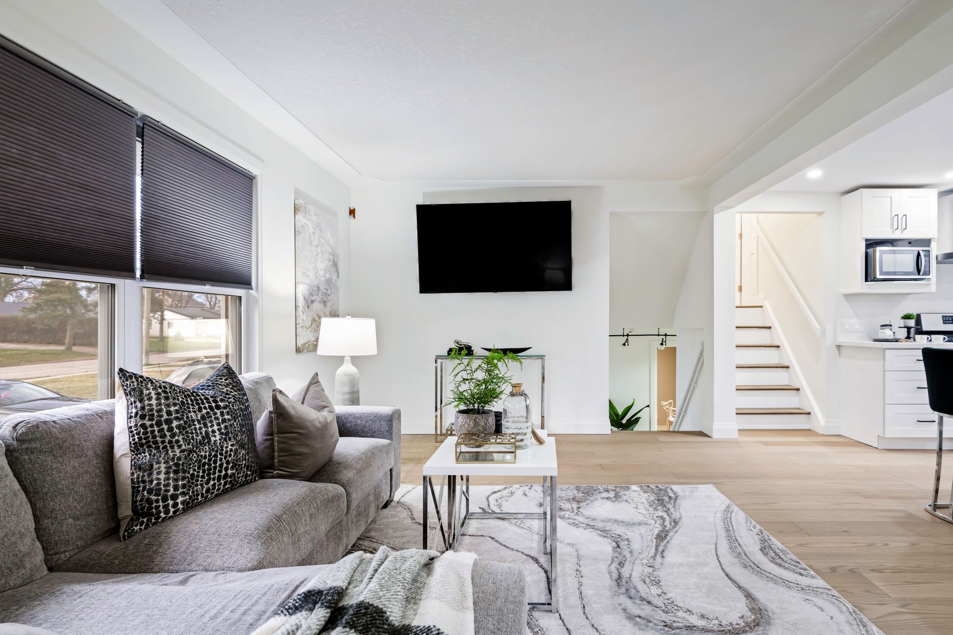 A living room with a couch and a television on the wall.
