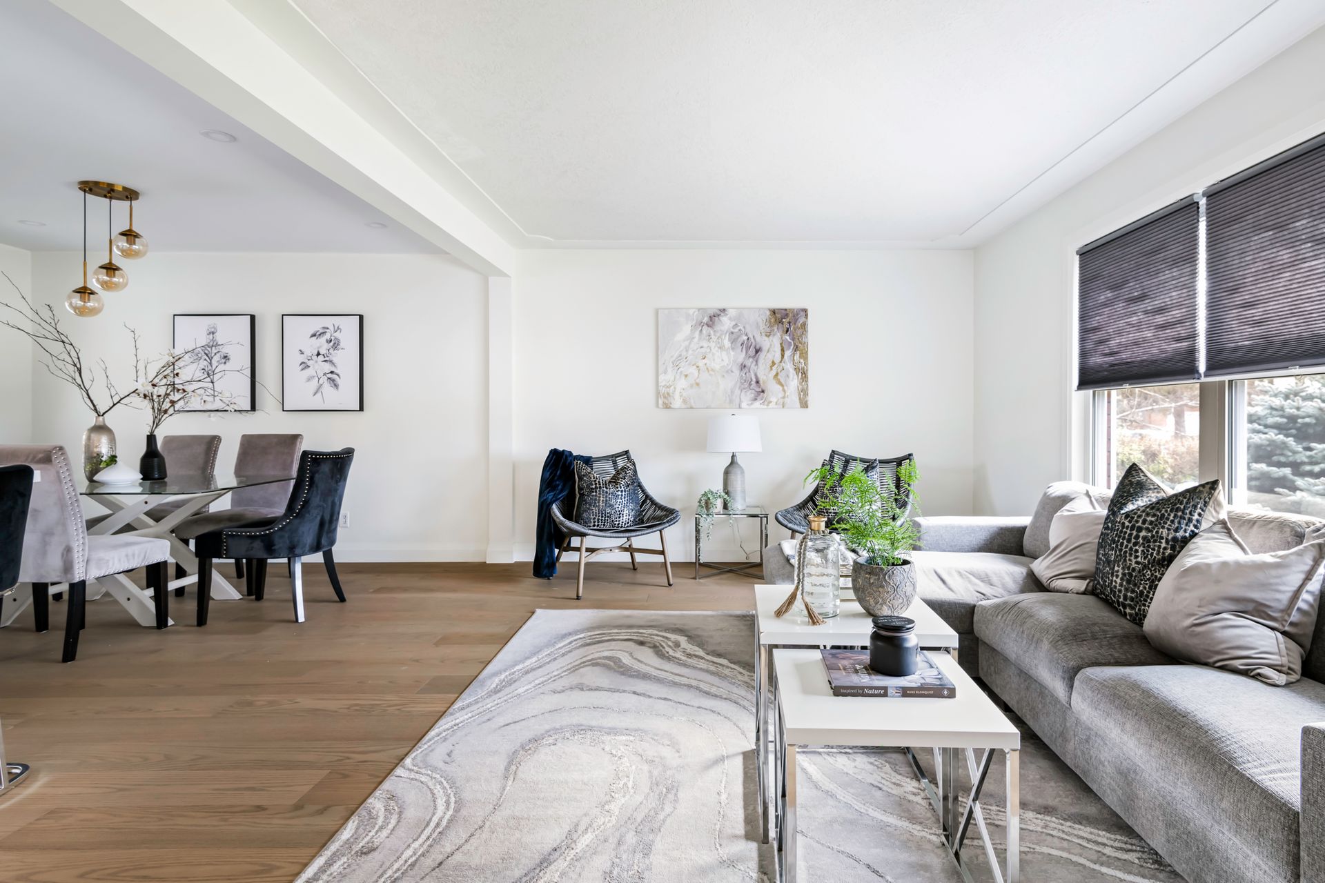 A living room with a couch , chairs , tables and a rug.