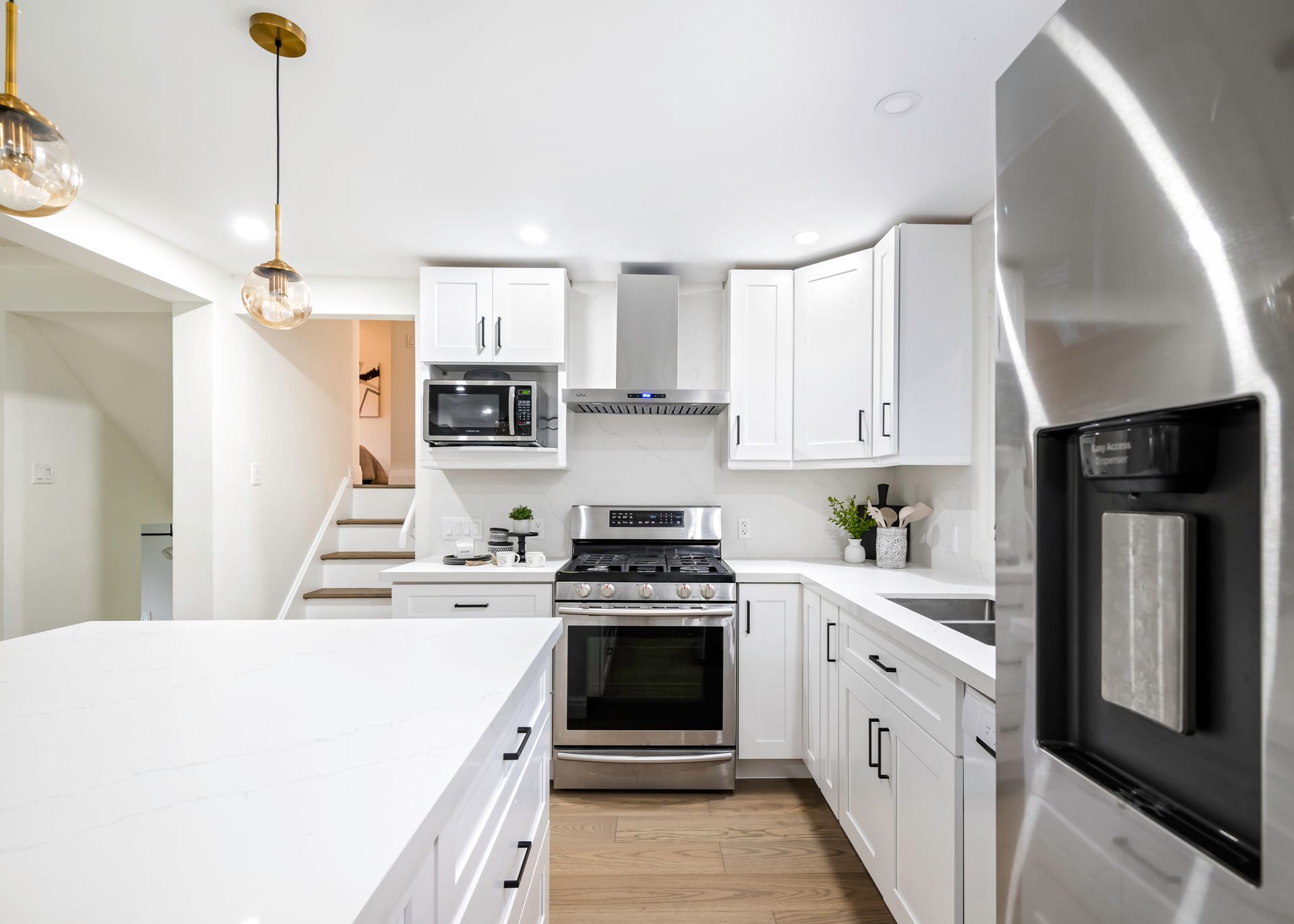 A kitchen with white cabinets and stainless steel appliances.