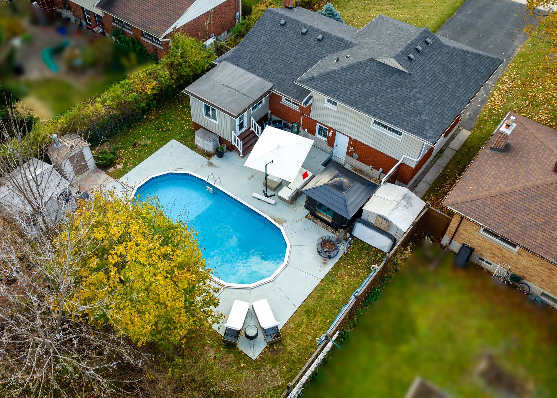 An aerial view of a house with a large swimming pool in the backyard.