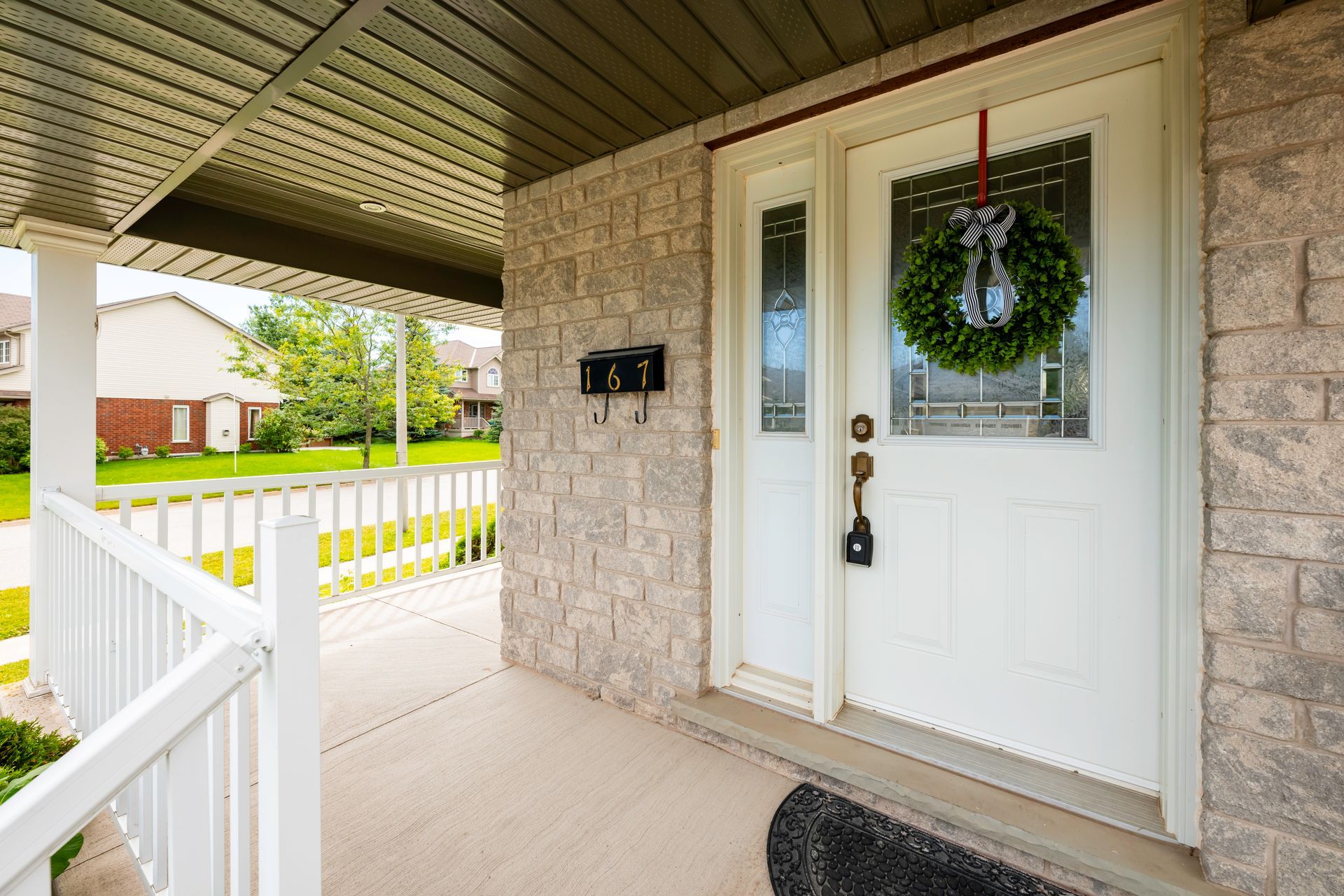 The front door of a house with a wreath hanging on it.