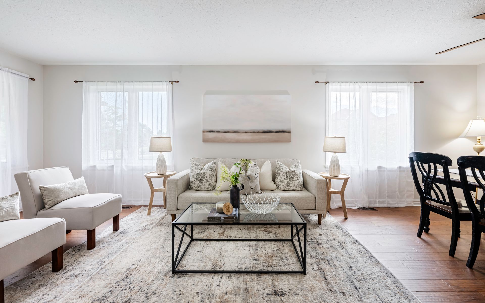 A living room with a couch , chairs , and a coffee table.