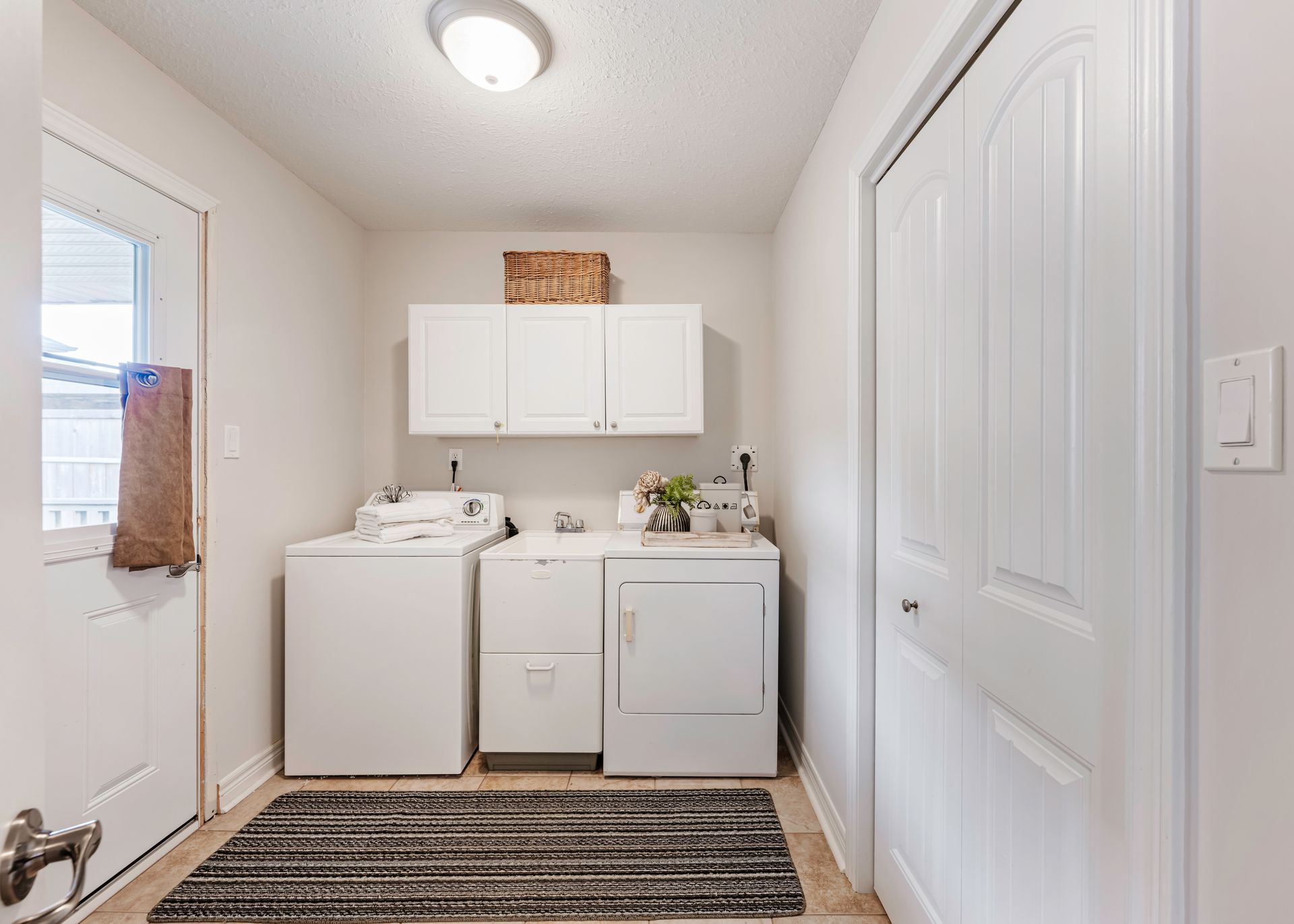A laundry room with a washer and dryer and a rug.
