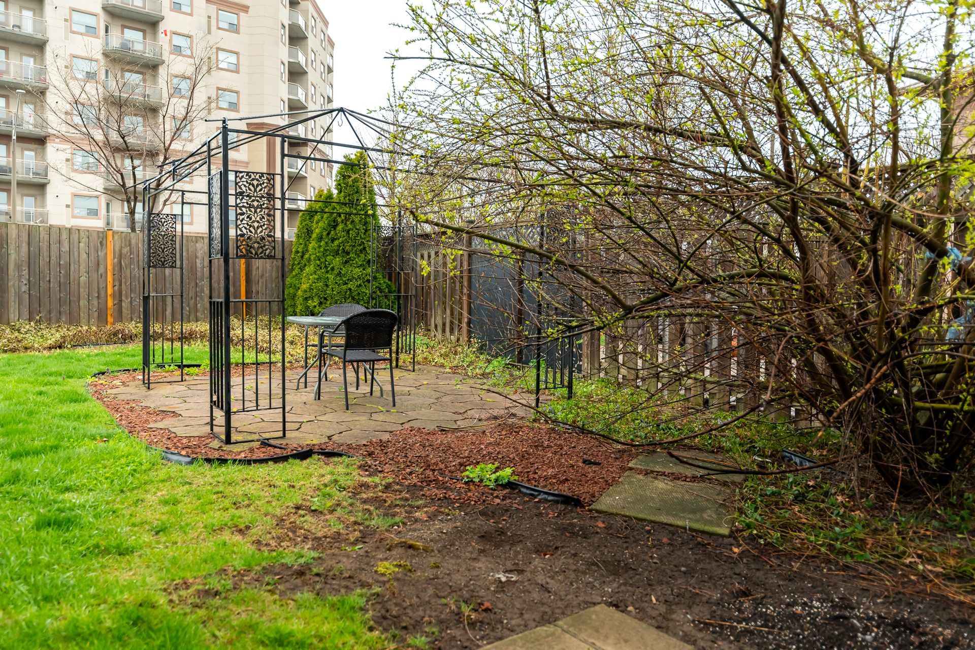 There is a gazebo in the backyard with a table and chairs.