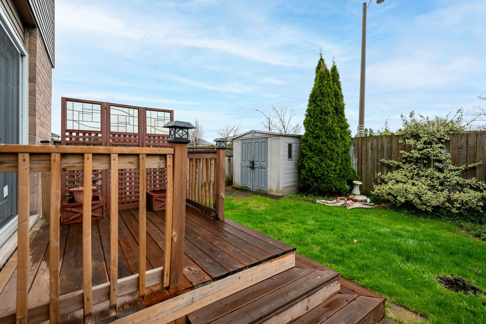 There is a wooden deck in the backyard of a house.