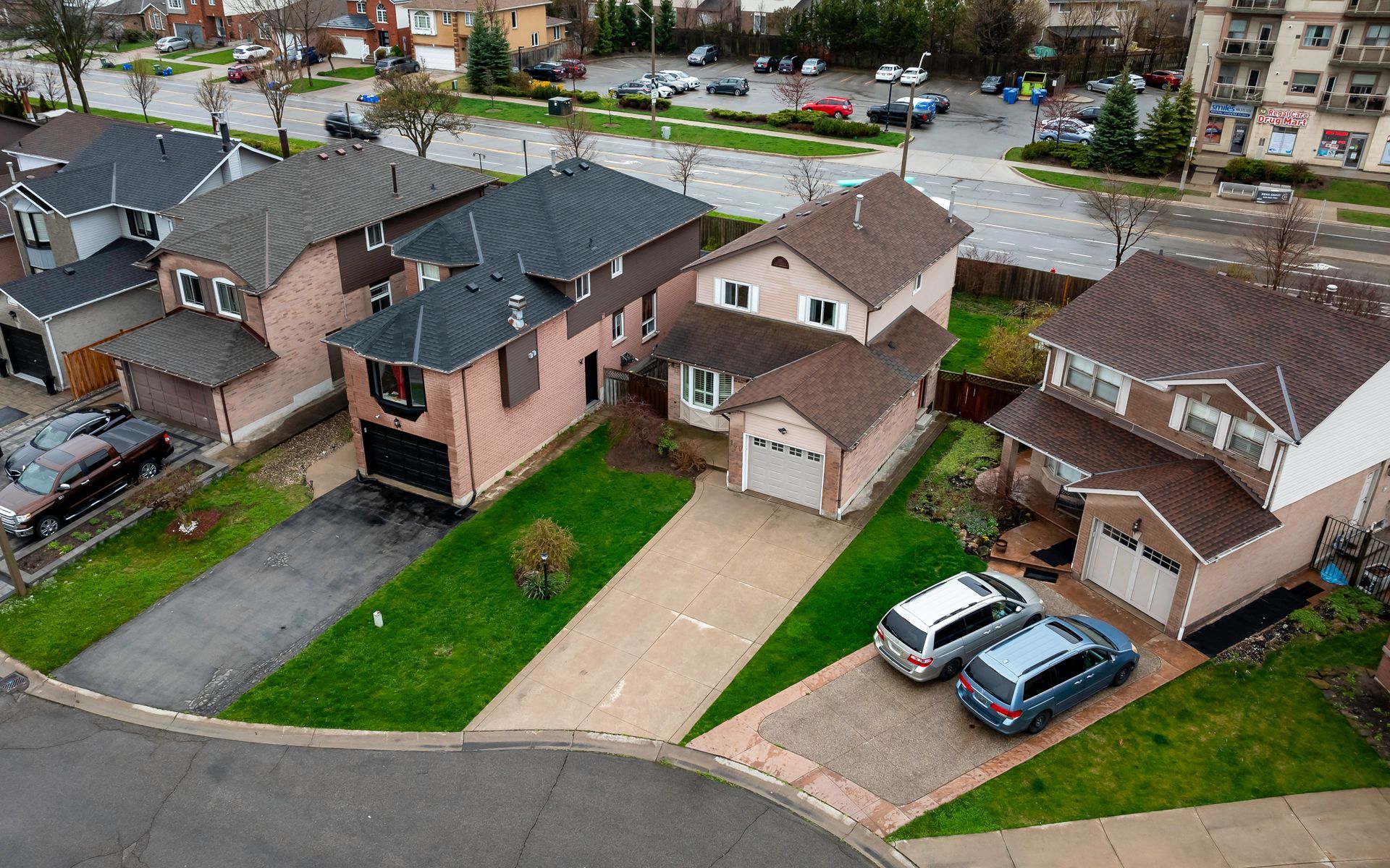 An aerial view of a residential neighborhood with houses and cars parked in front of them.