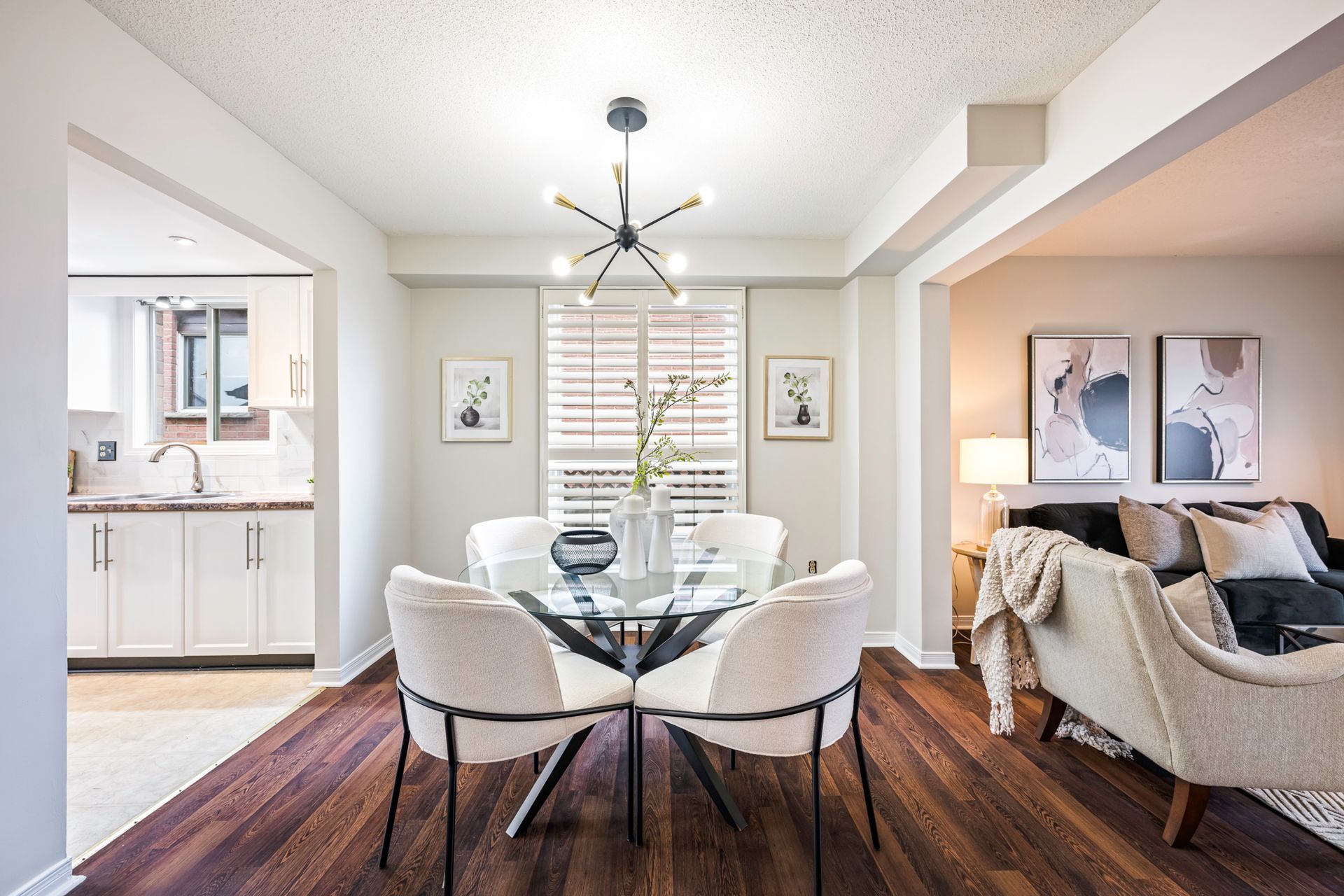 A dining room with a glass table and chairs in a house.
