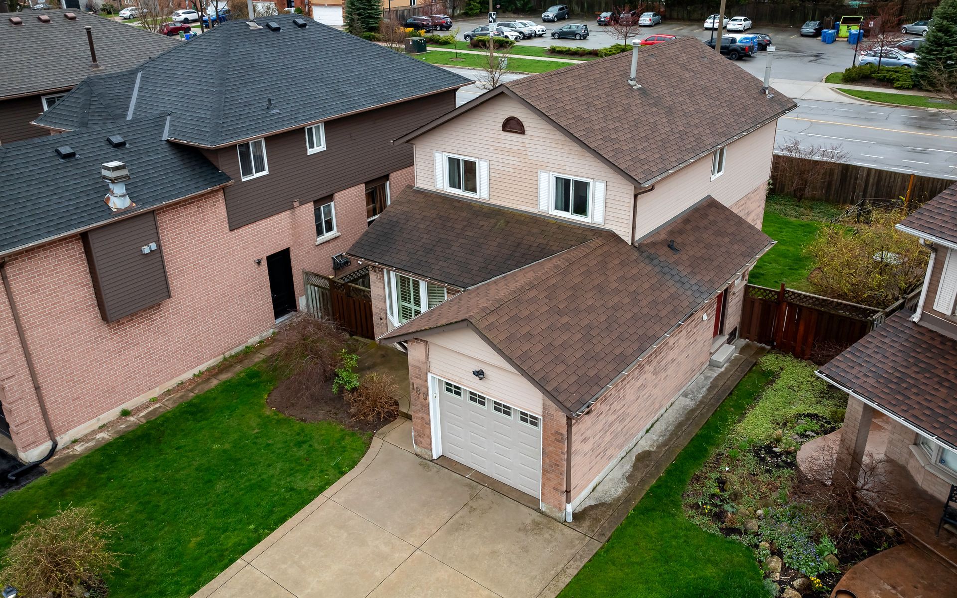 An aerial view of a house with a garage in a residential area.