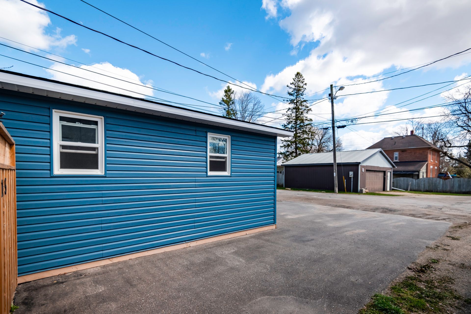 A blue house with a garage and a fence in front of it