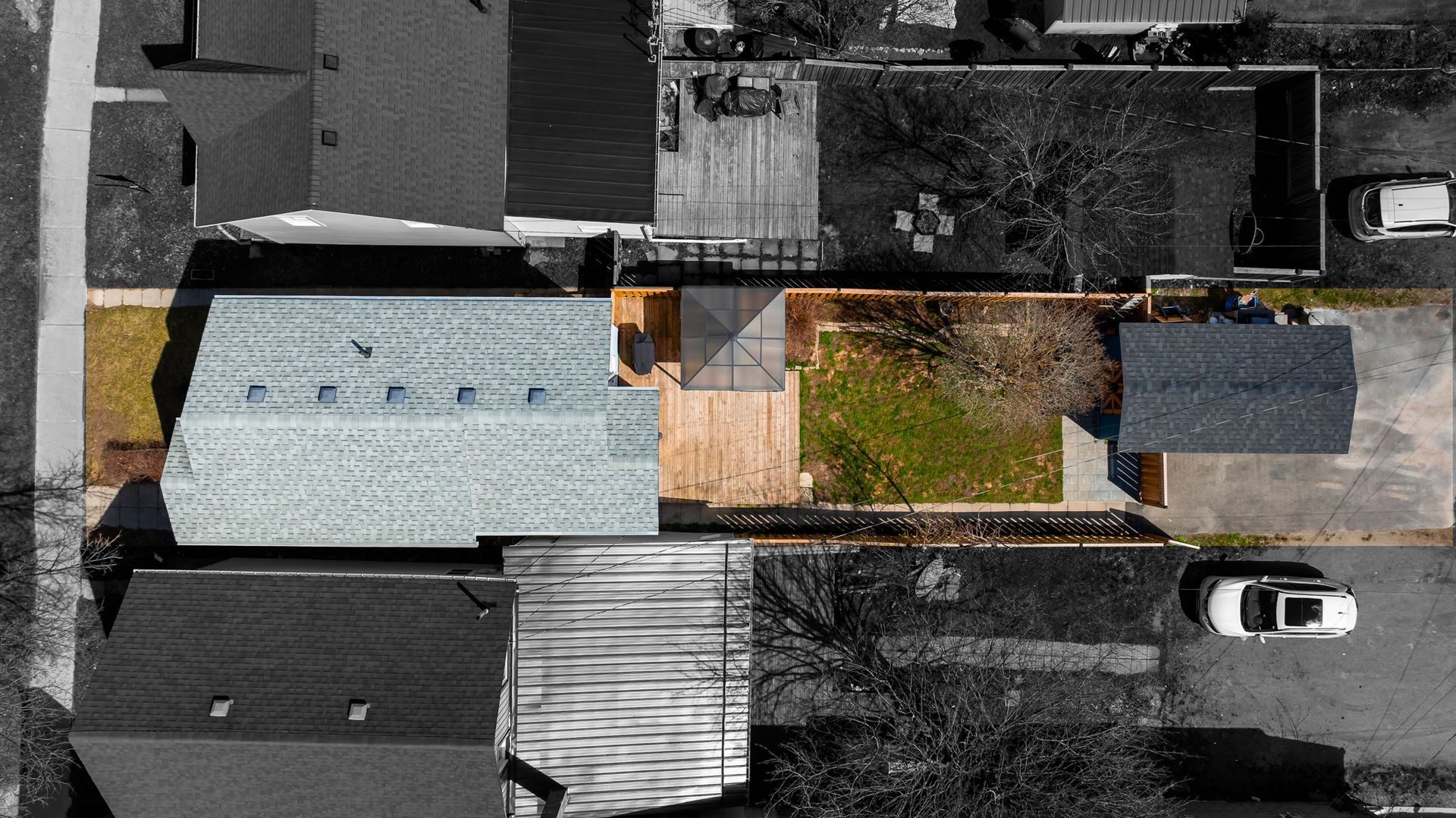 An aerial view of a residential neighborhood with a car parked in the driveway.