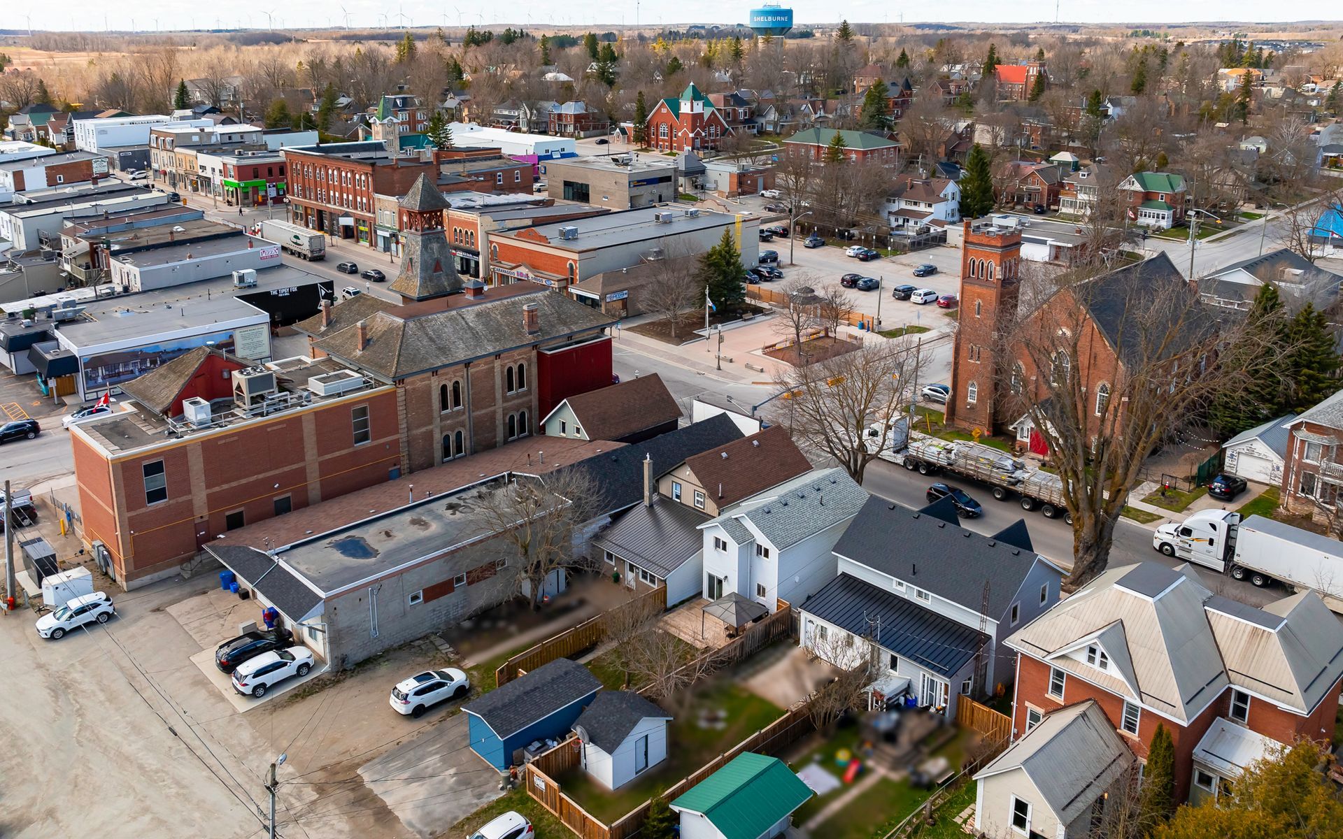 An aerial view of a small town with lots of buildings and a water tower.