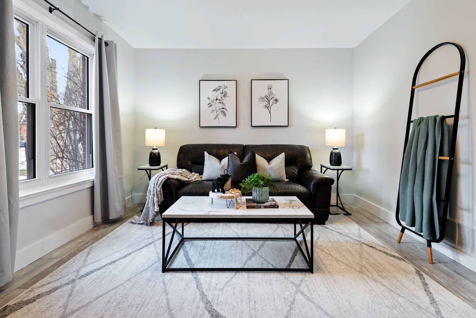 A living room with a couch , coffee table , lamps and a rug.