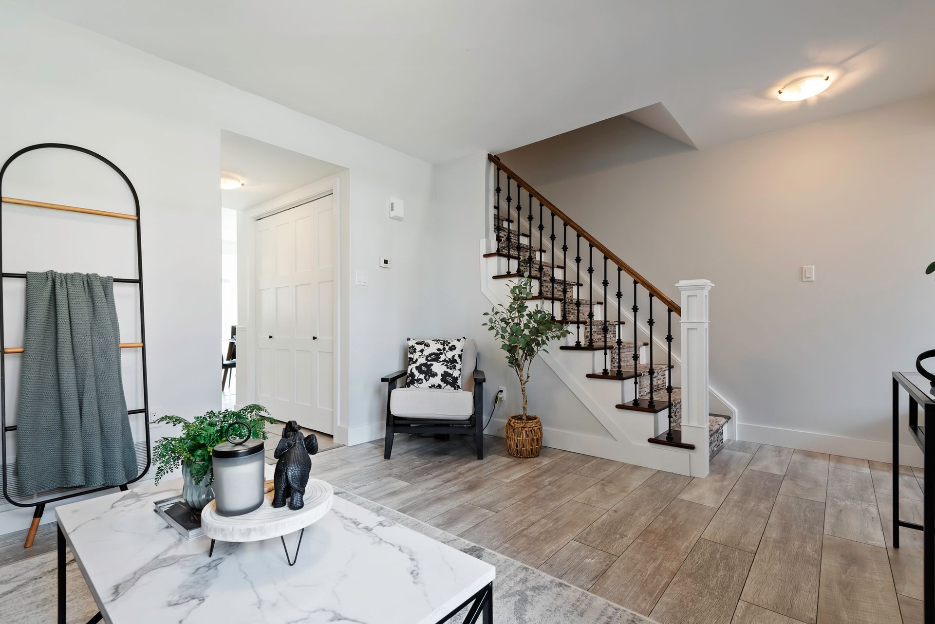 A living room with a coffee table , chair , and stairs.
