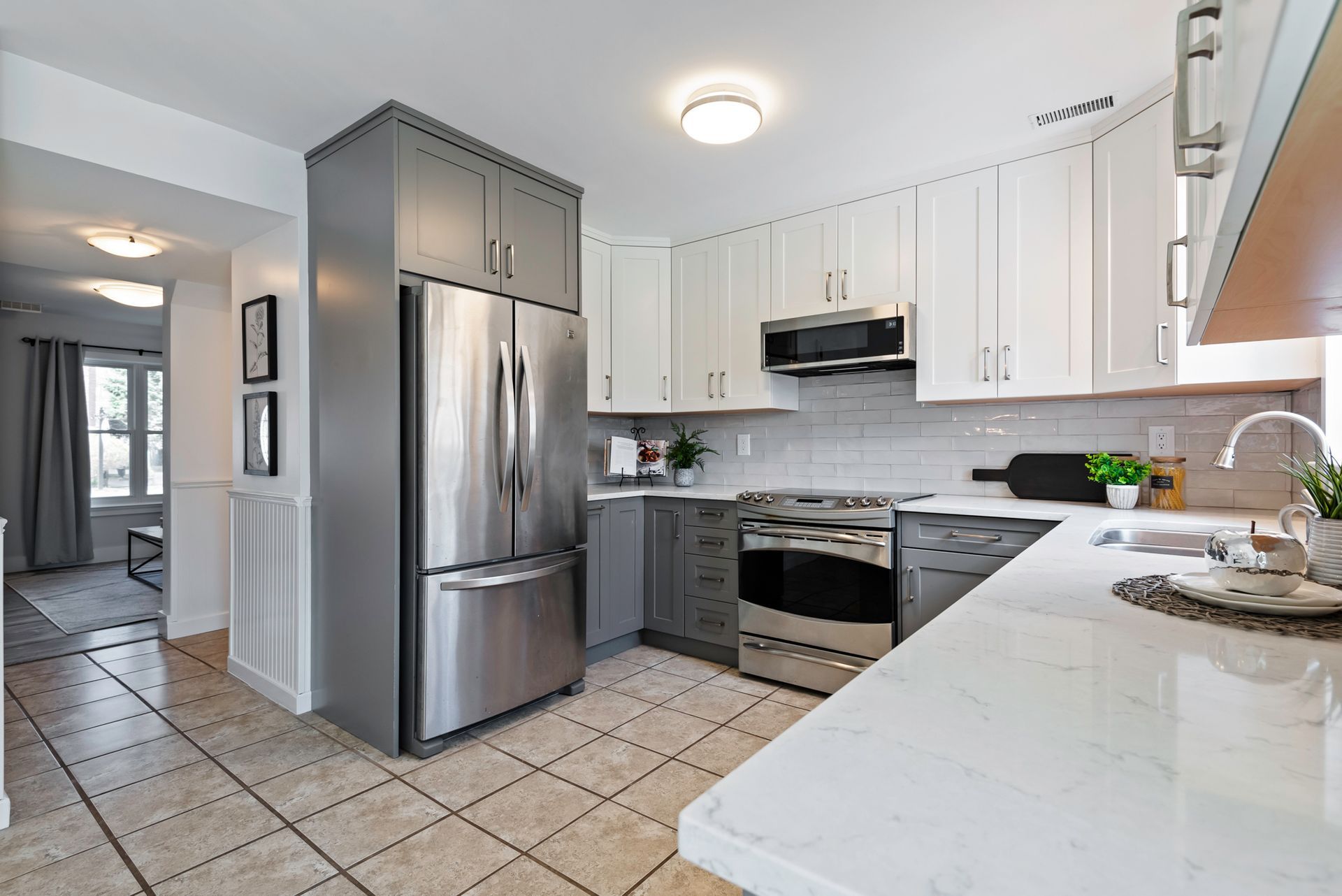 A kitchen with stainless steel appliances and white cabinets.