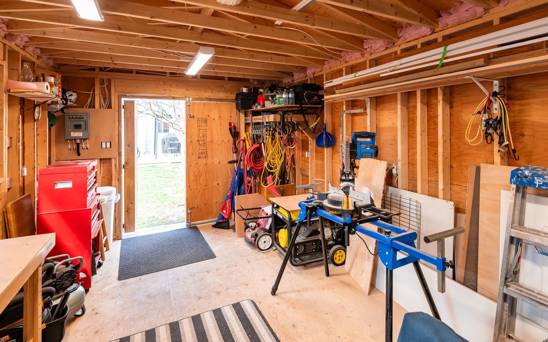 A garage filled with lots of tools and a table saw.