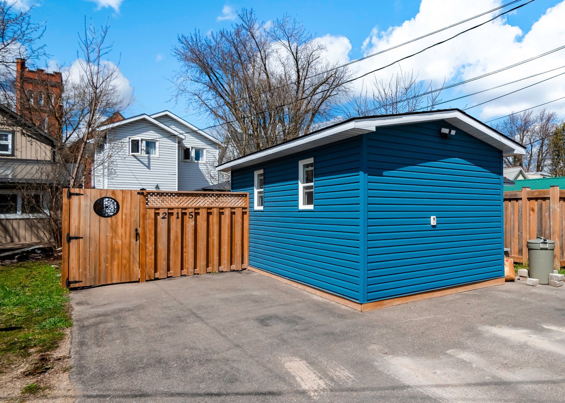 A blue garage with a wooden gate in front of it