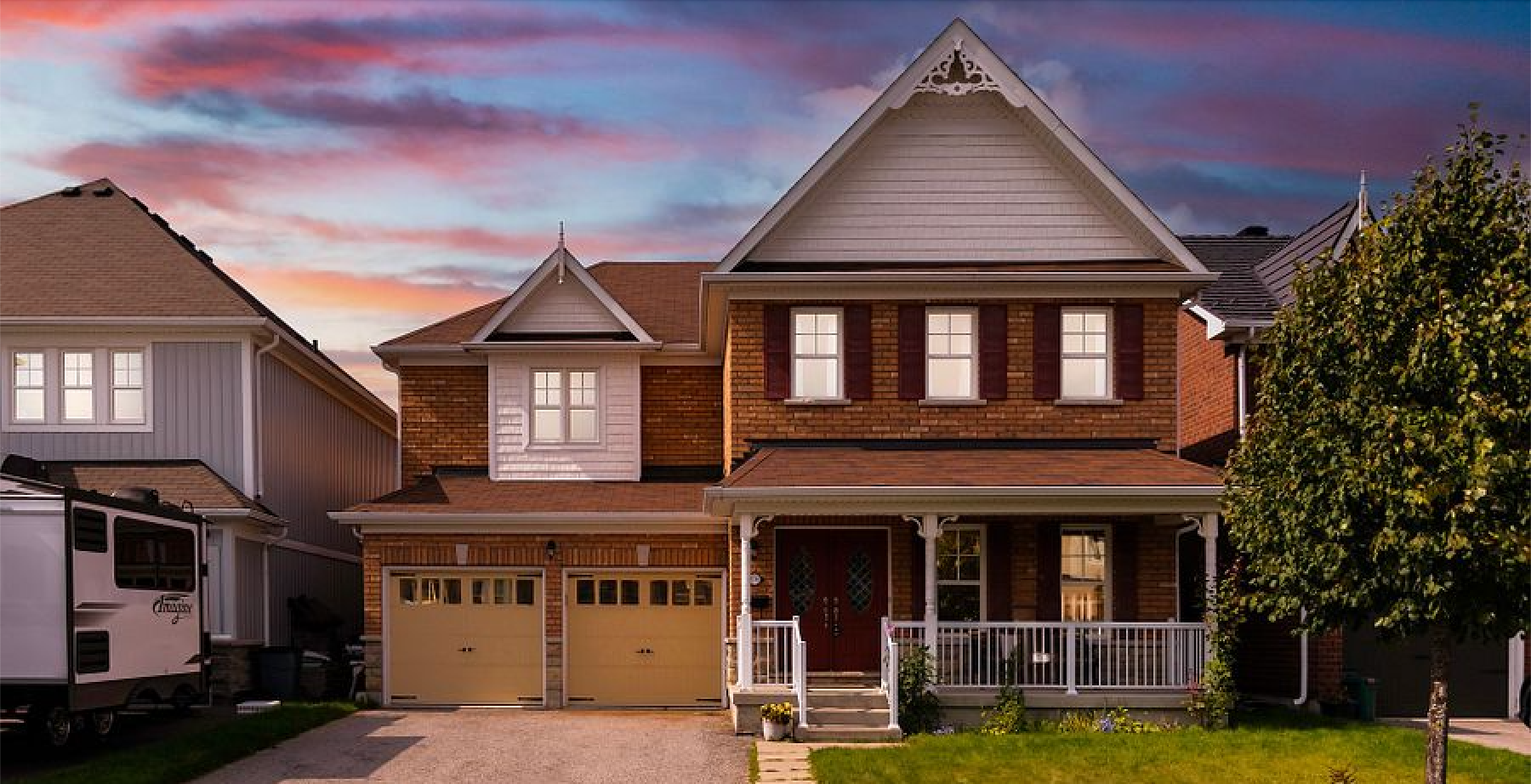 A large brick house with a porch and two garages is for sale.