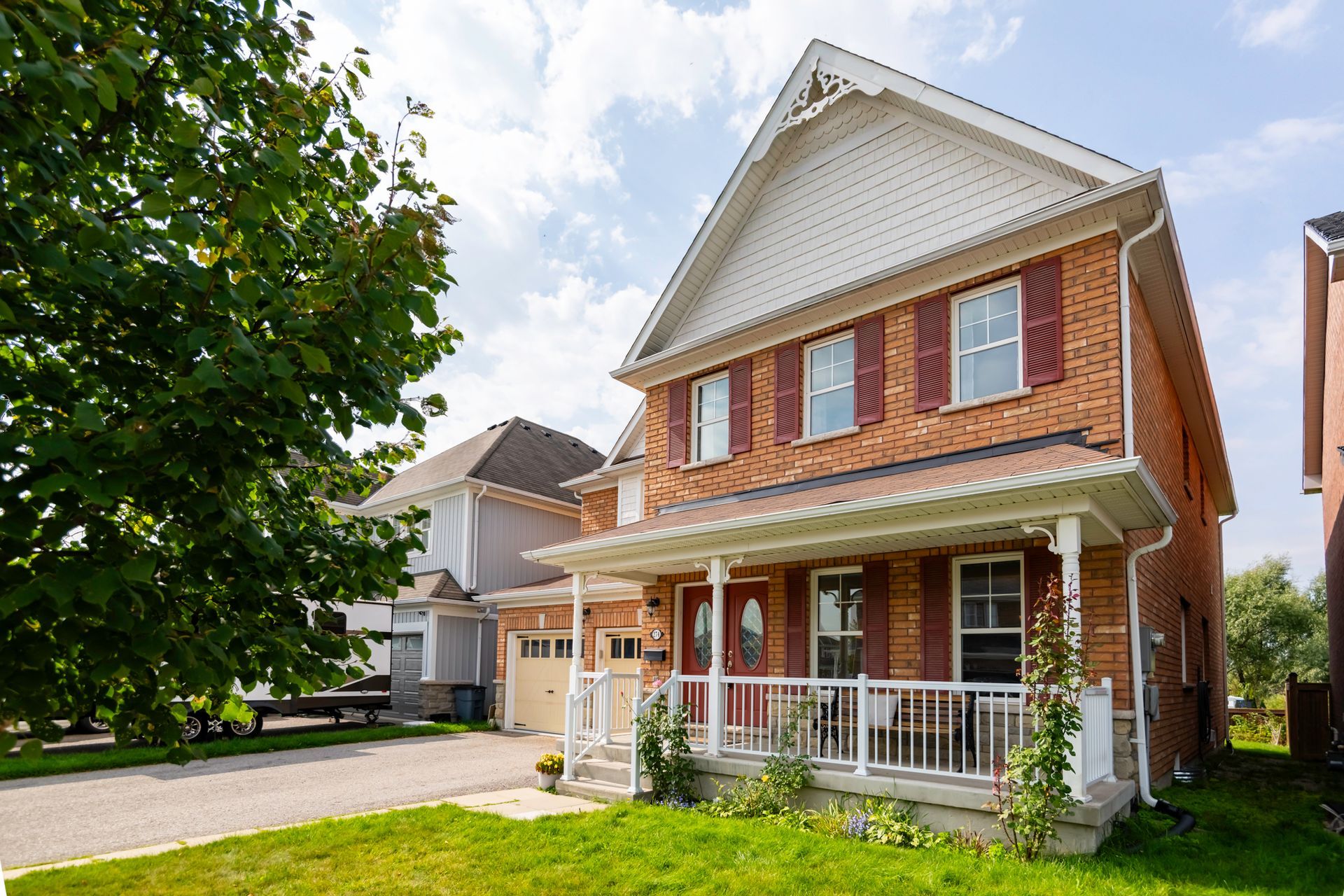 A brick house with a large porch and a white trim