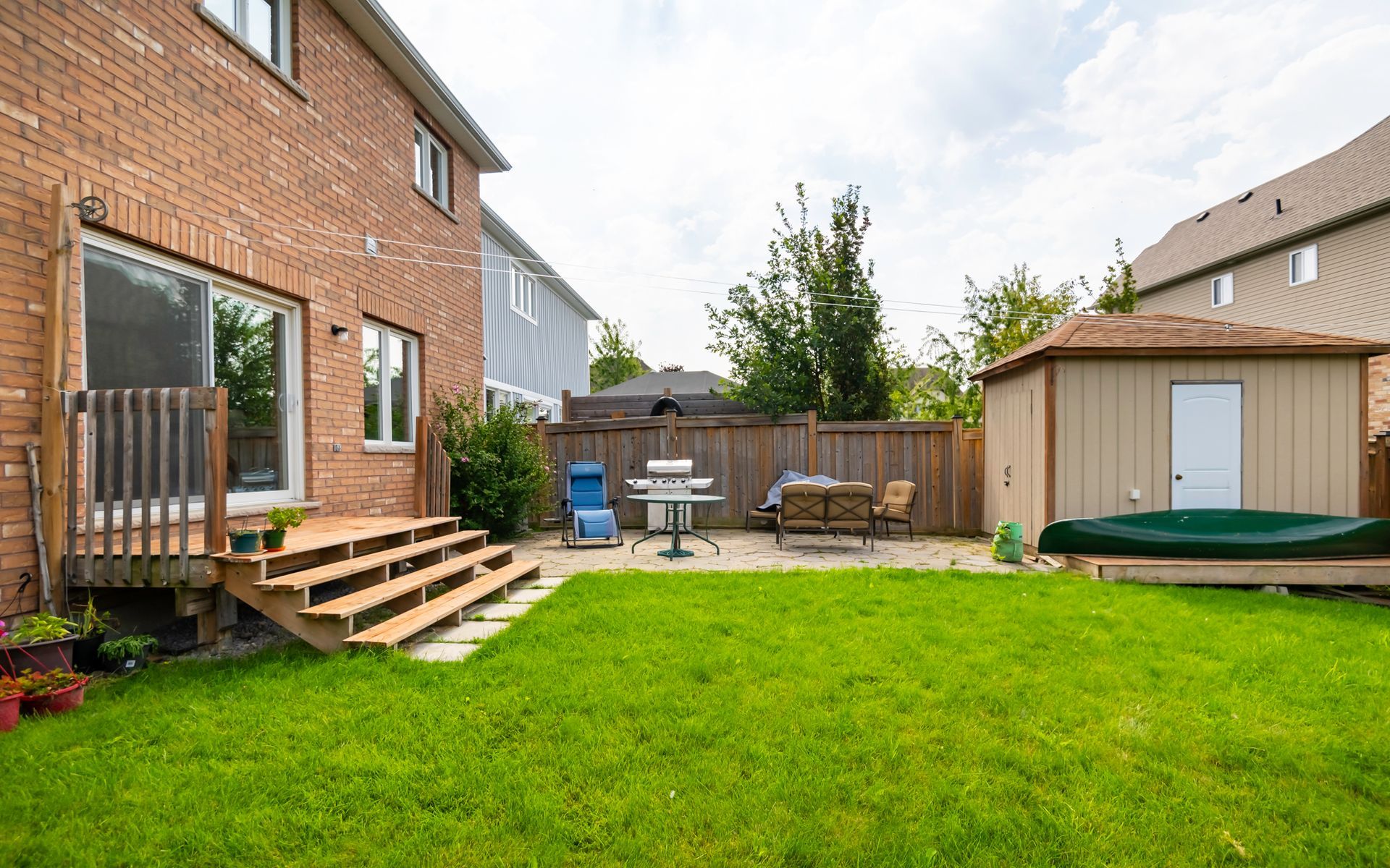 The backyard of a house with a large lawn and a shed.