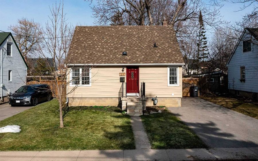 A small house with a red door and a car parked in front of it.