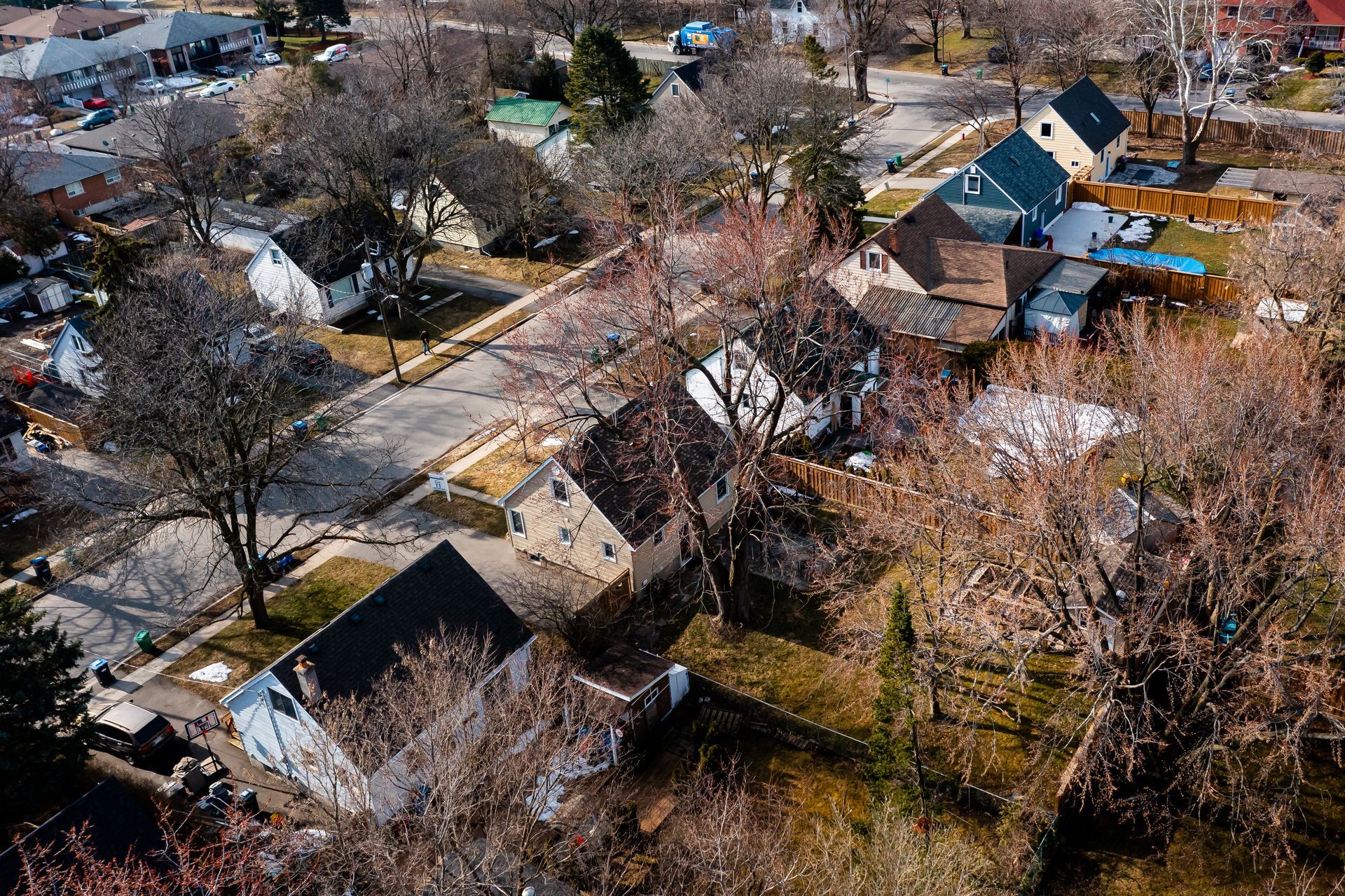 An aerial view of a residential area with houses and trees.