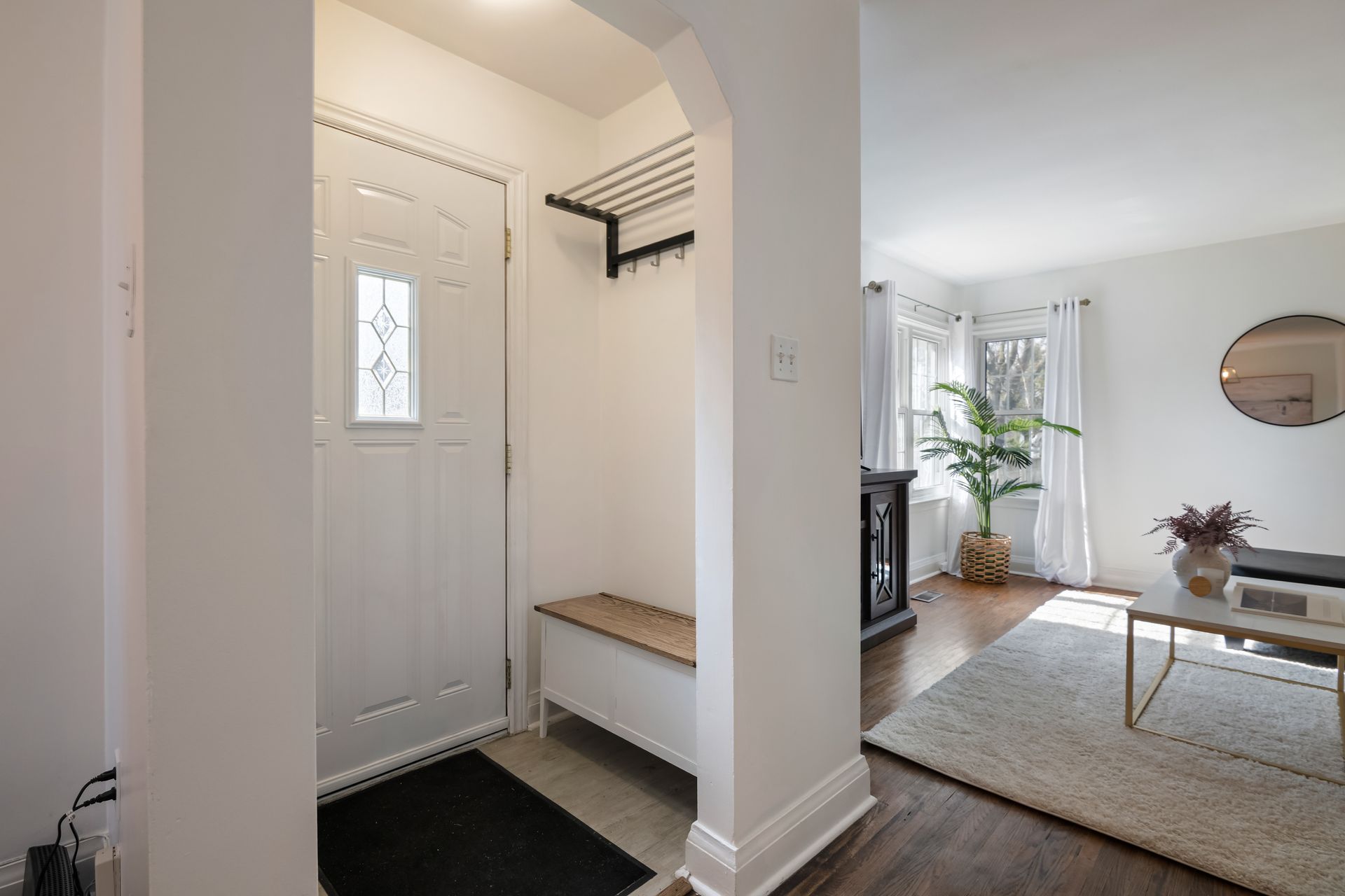 A hallway in a house with a bench and a coffee table.