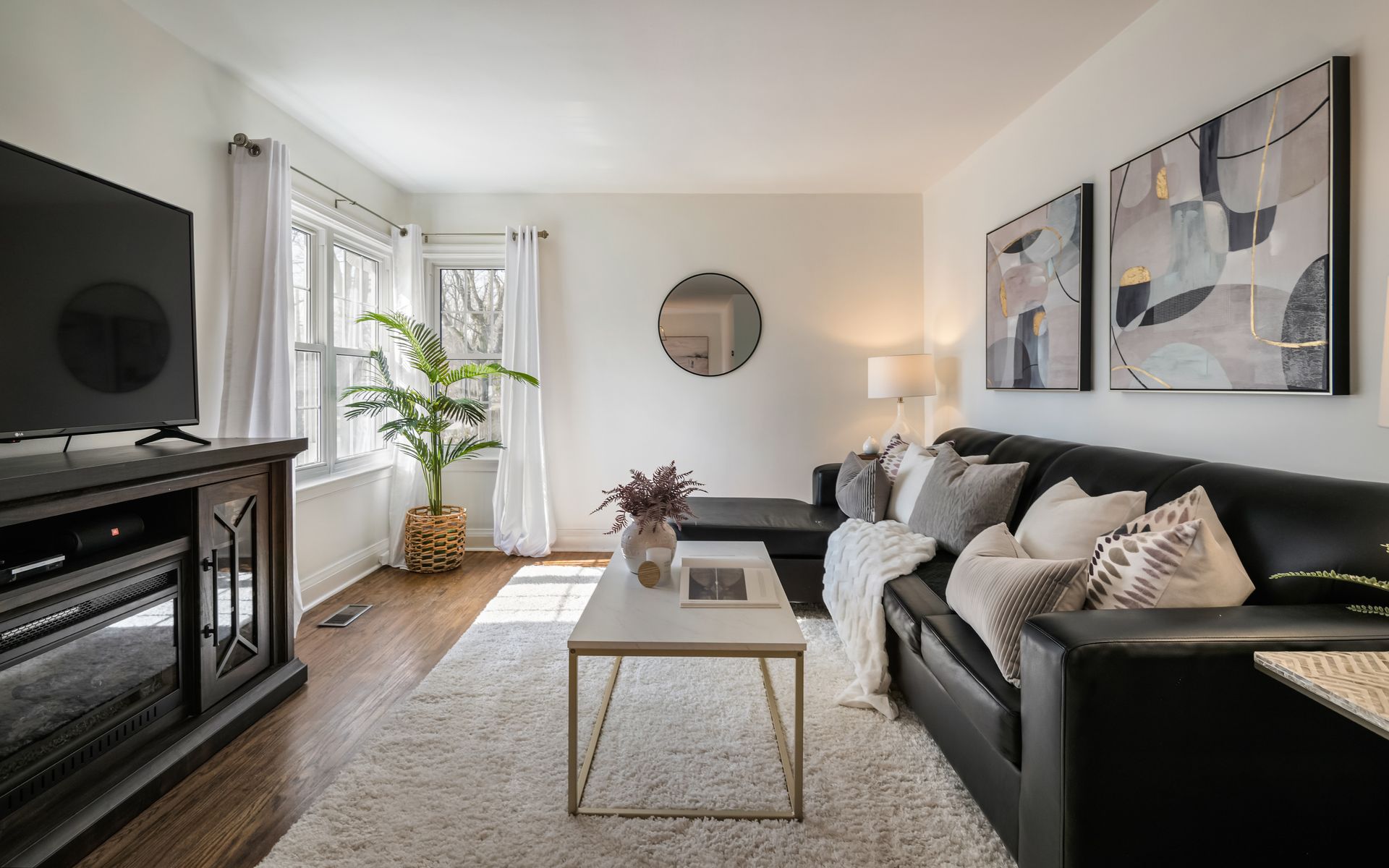 A living room with a couch , coffee table , television and fireplace.