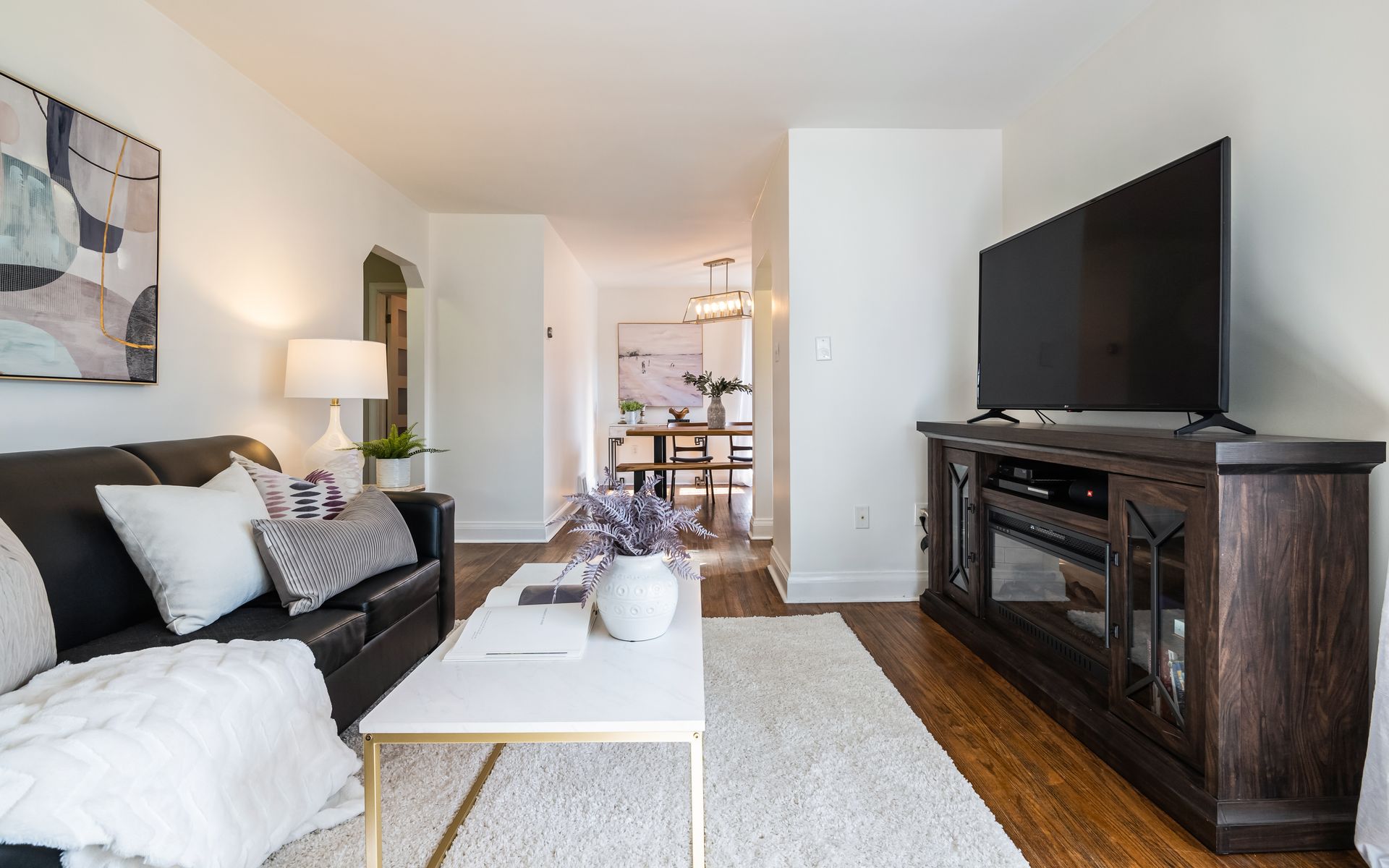A living room with a couch , coffee table , and television.