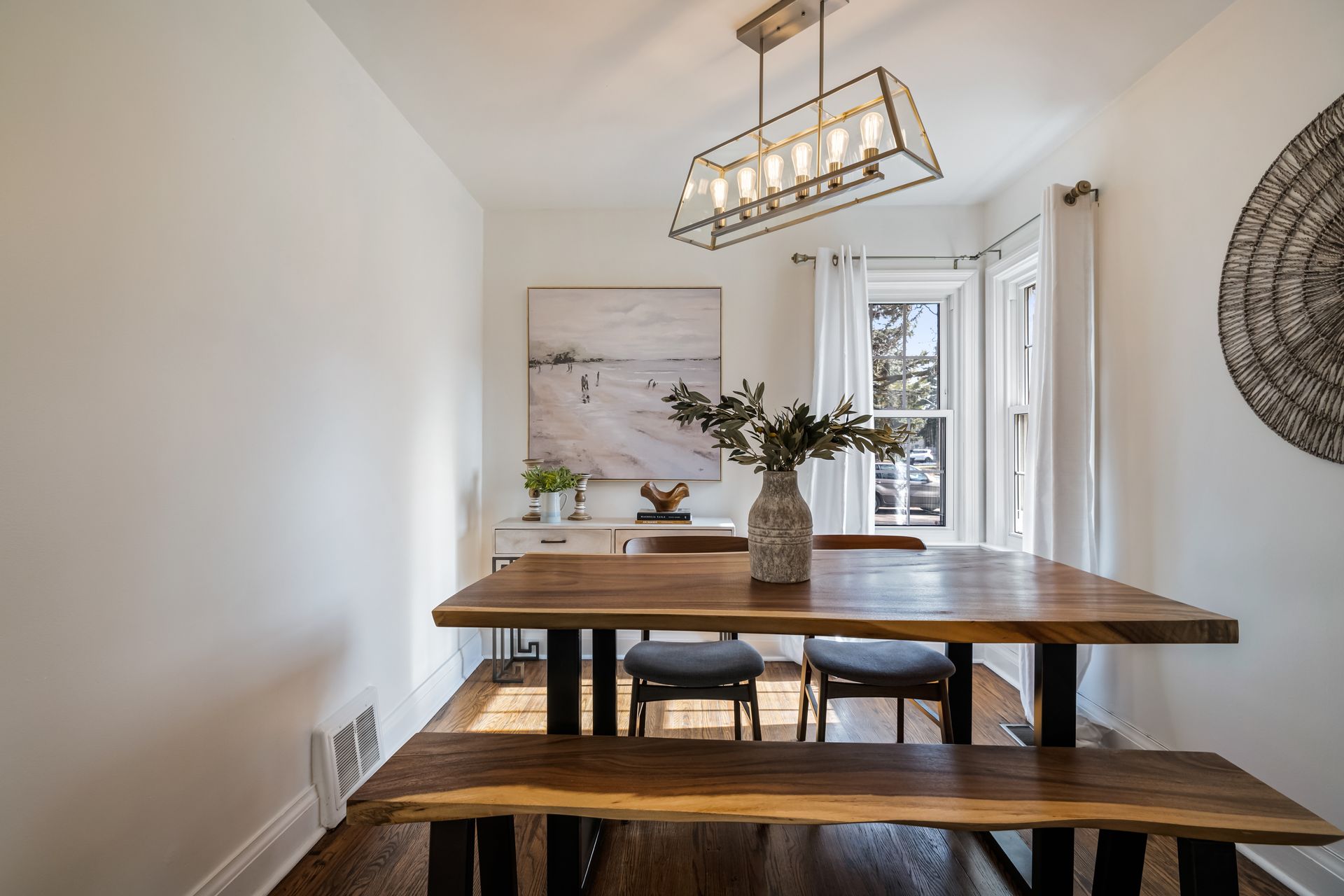A dining room with a wooden table and benches.