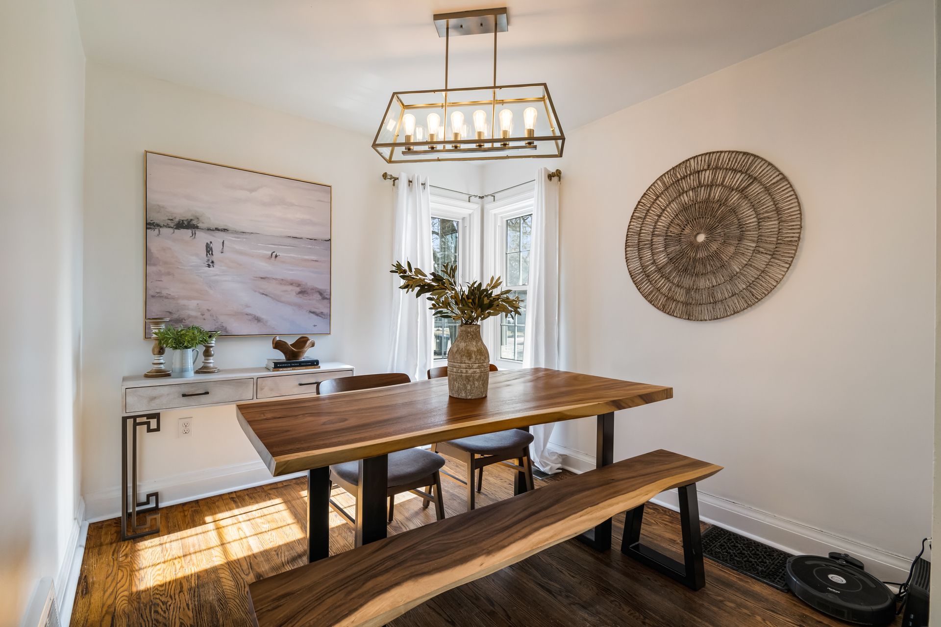A dining room with a wooden table and benches.