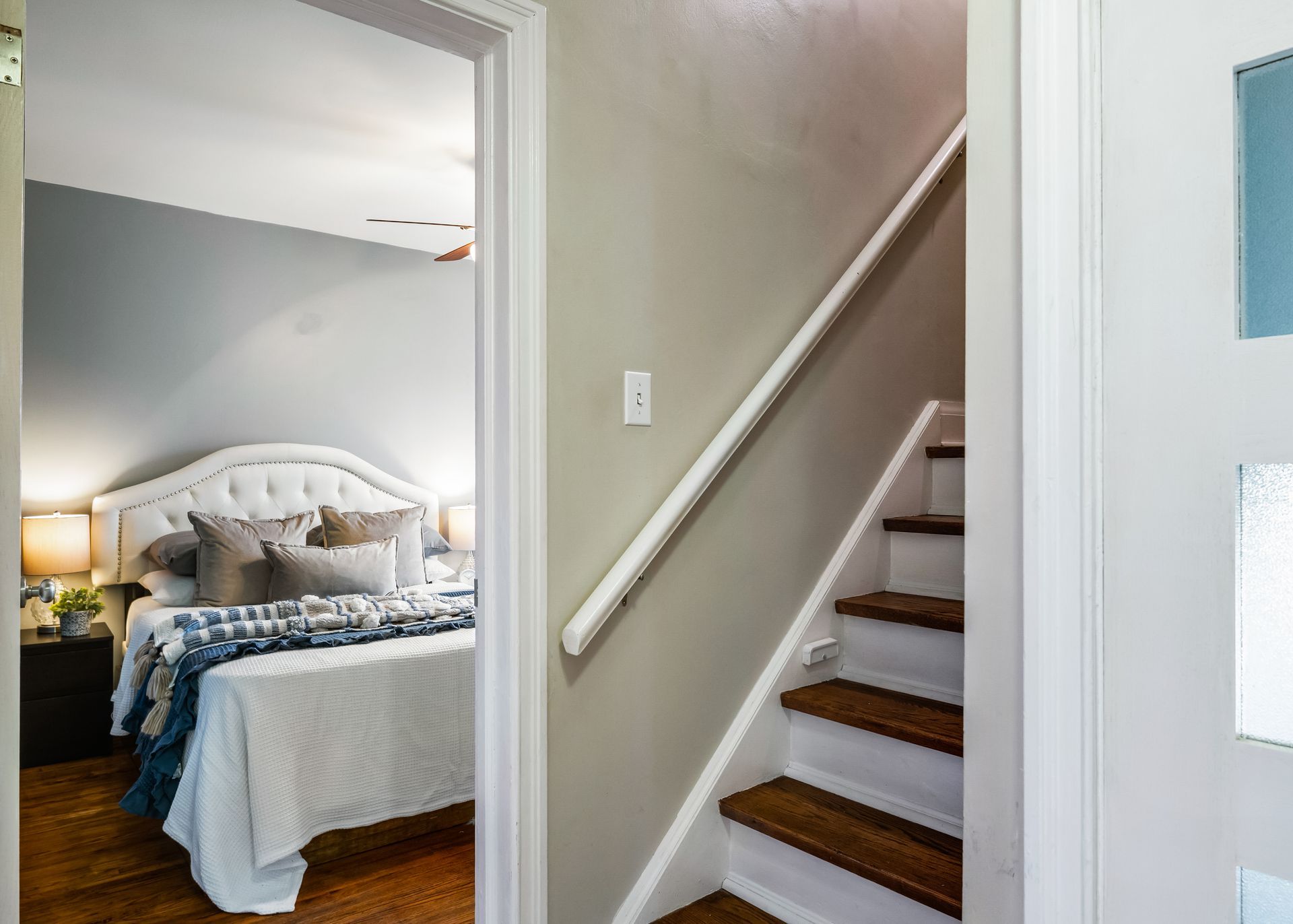 A bedroom with a bed and stairs leading up to it.