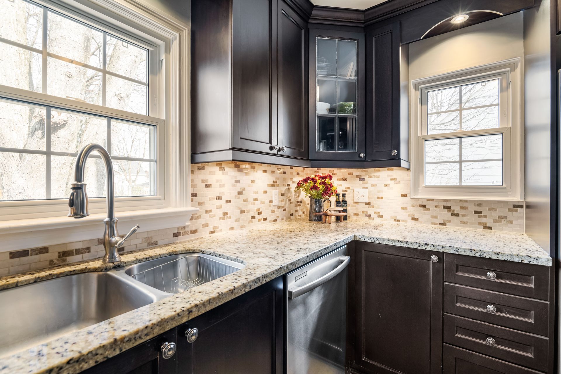 A kitchen with a sink , dishwasher , and window.