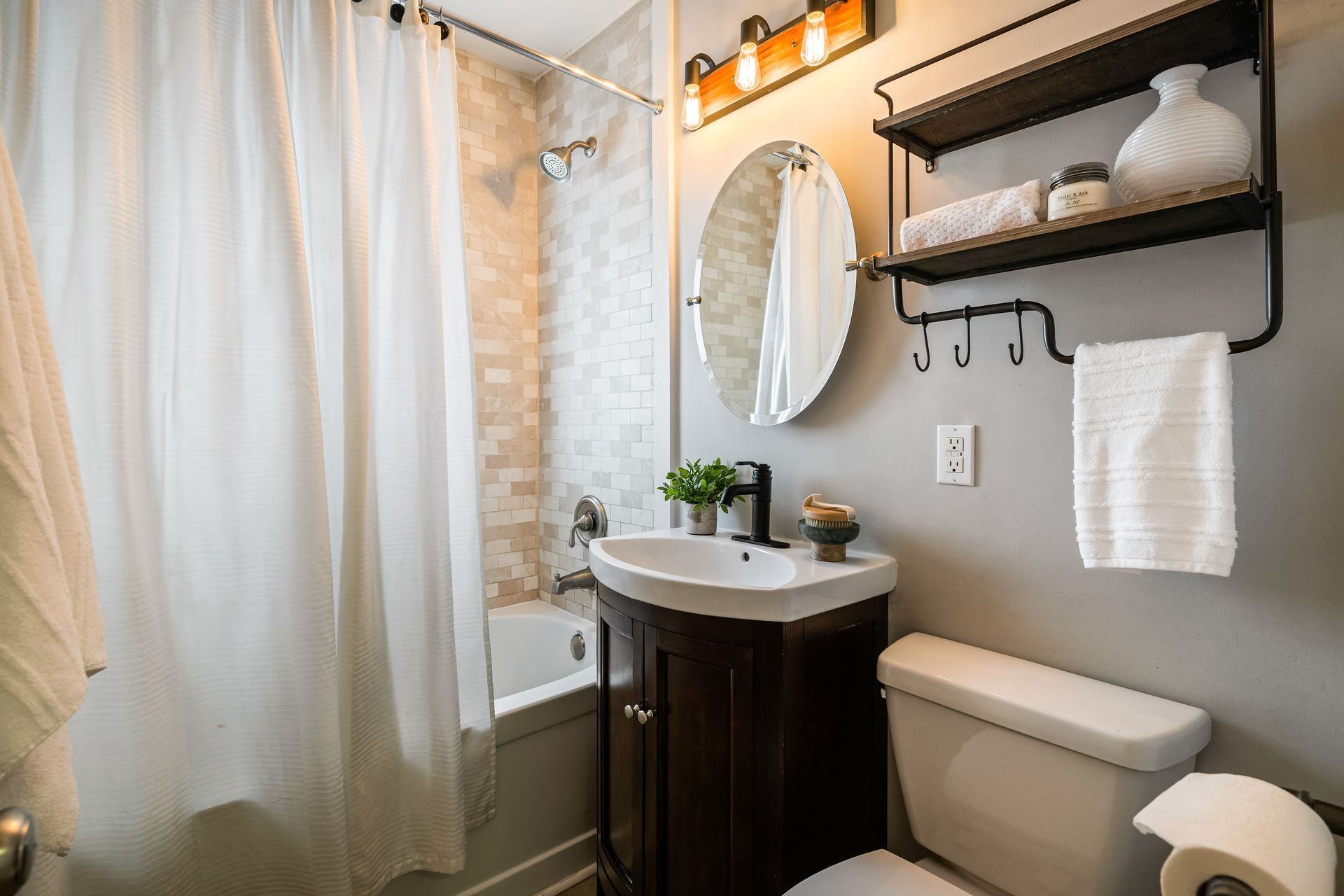 A bathroom with a sink , toilet , bathtub and mirror.