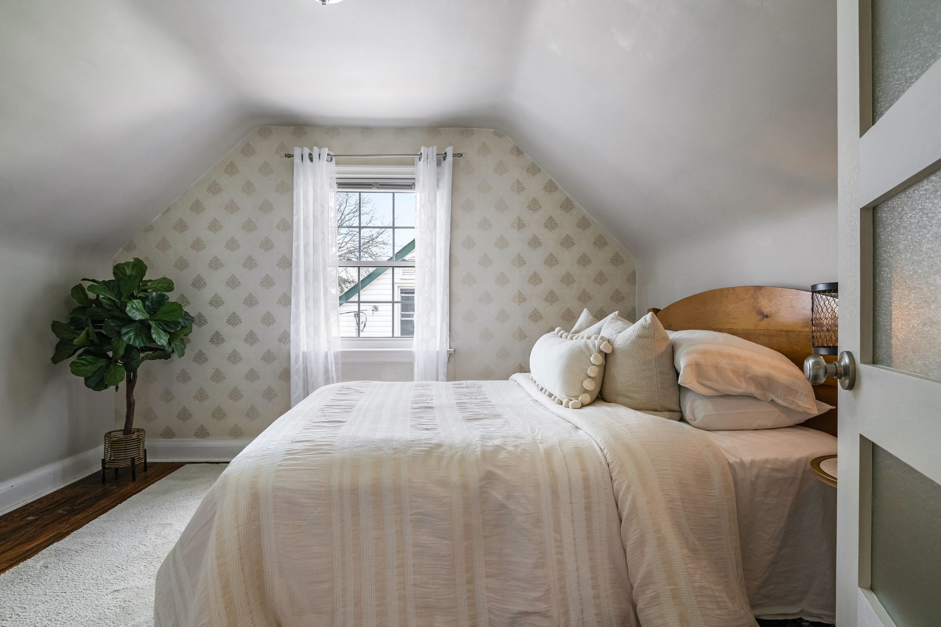 A bedroom with a bed and a window in the attic.