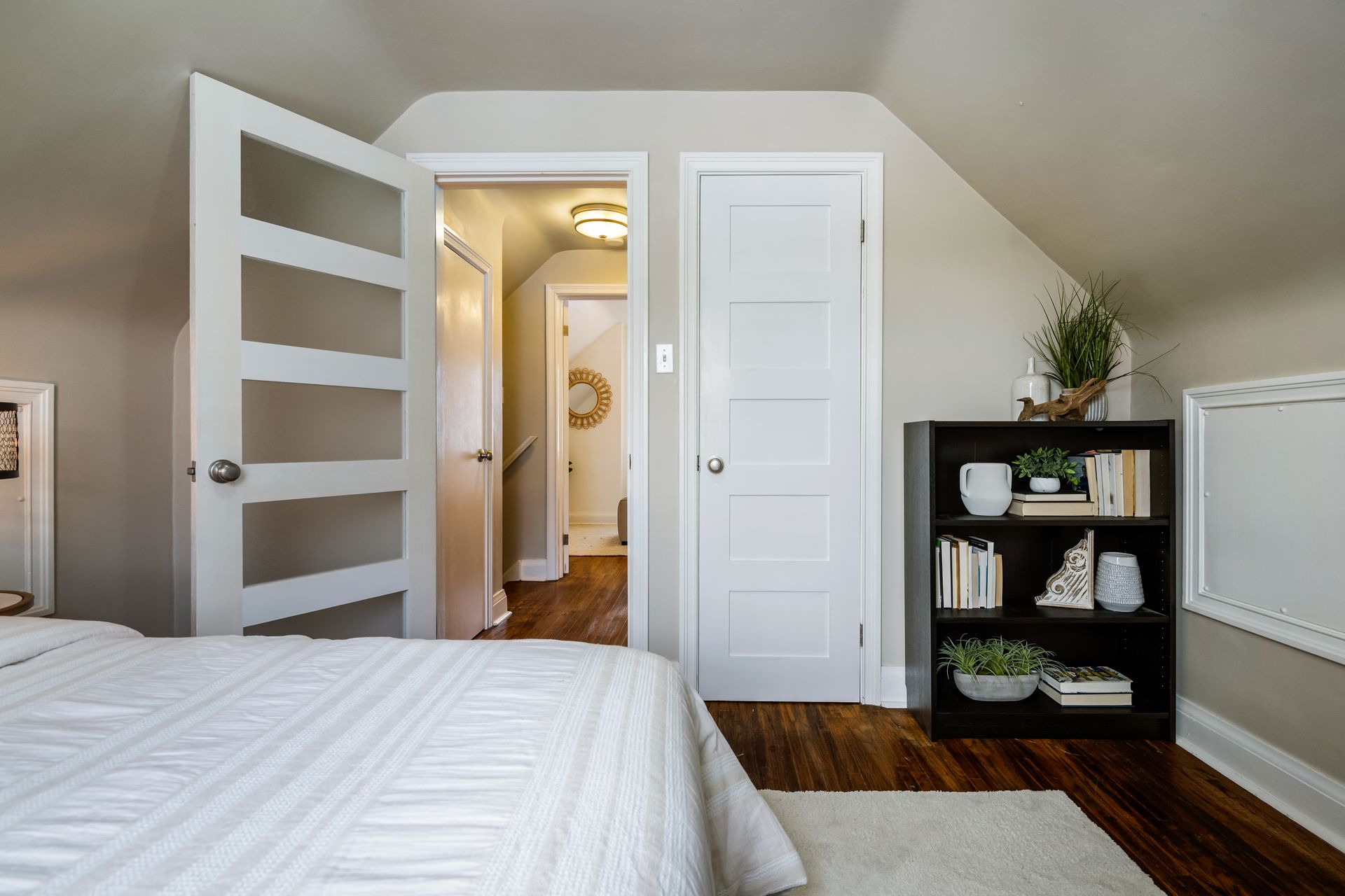 A bedroom with a bed , bookshelf , and closet.