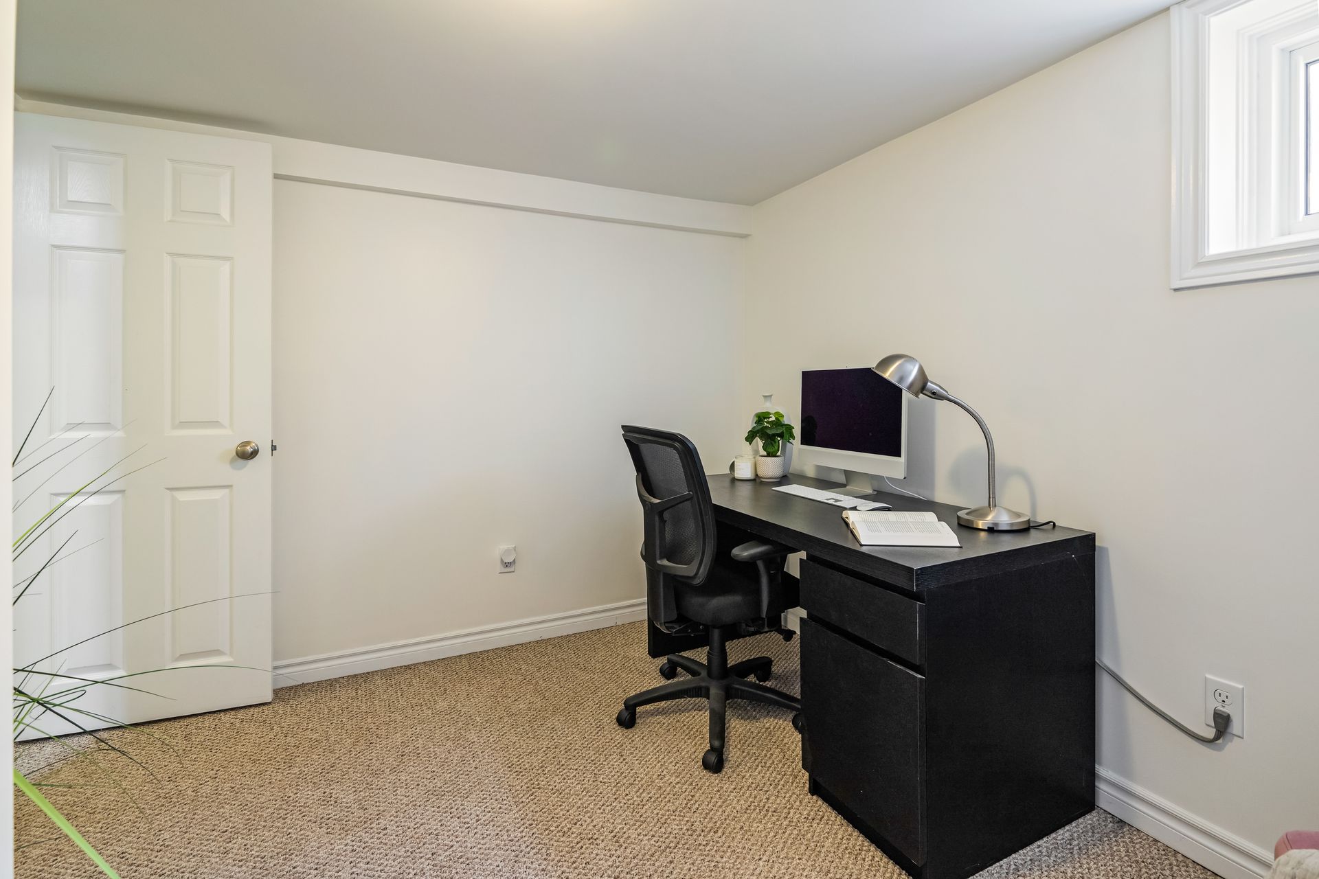 A room with a desk and chair and a computer on it.