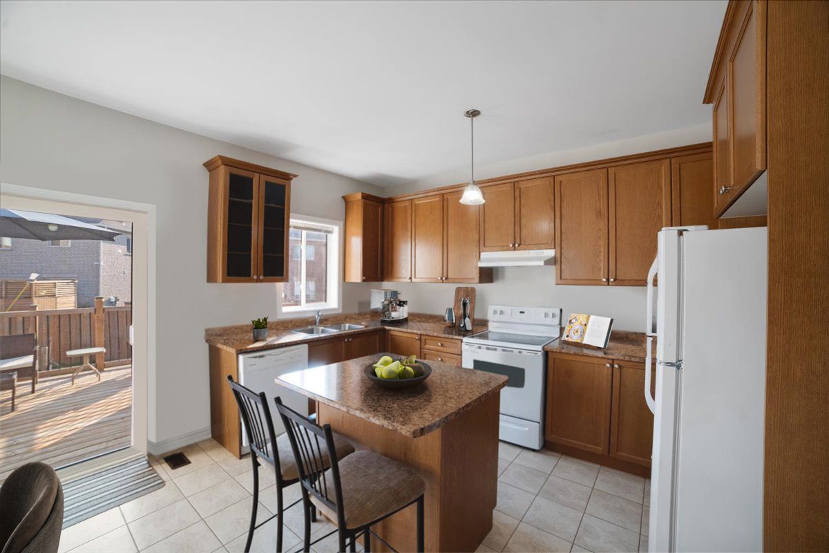A kitchen with wooden cabinets , a refrigerator , a stove and a sink.