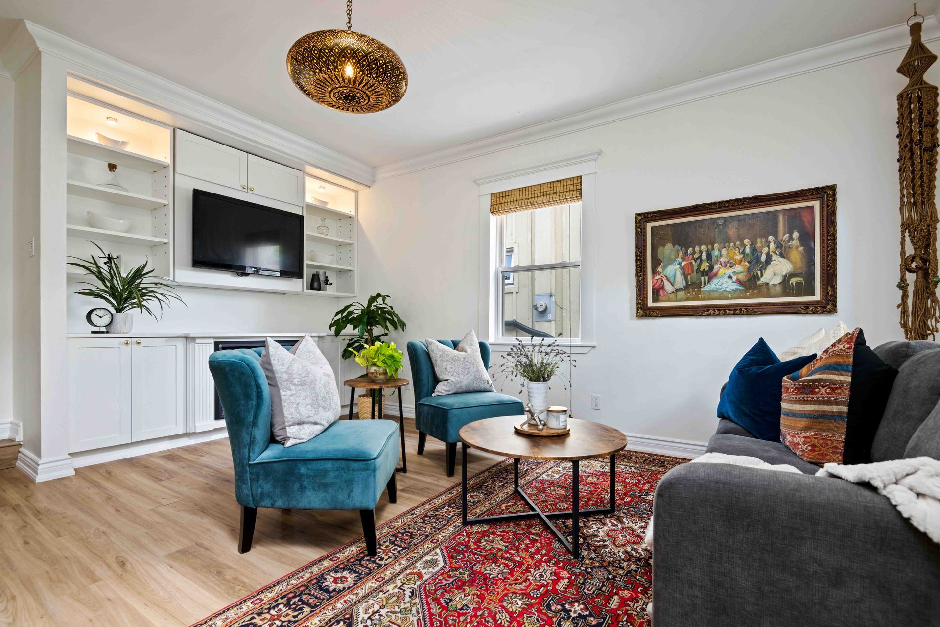 A living room with a couch , chairs , a rug and a television.