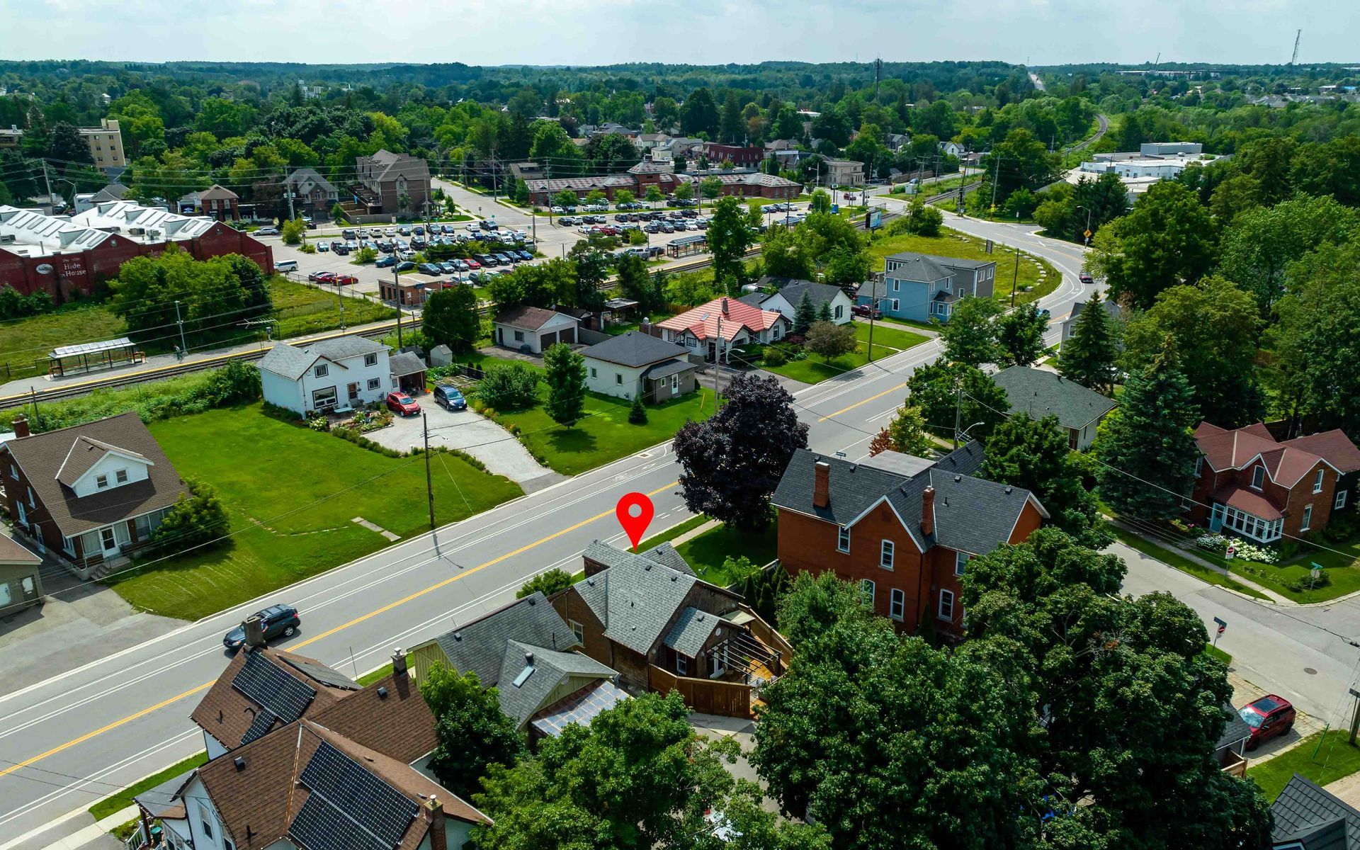 An aerial view of a residential area with a red pin pointing the location of a house.