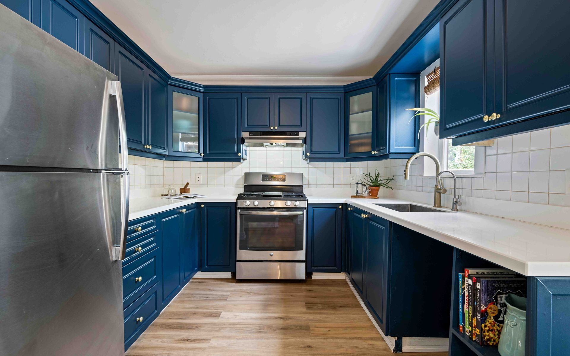 A kitchen with blue cabinets and stainless steel appliances.