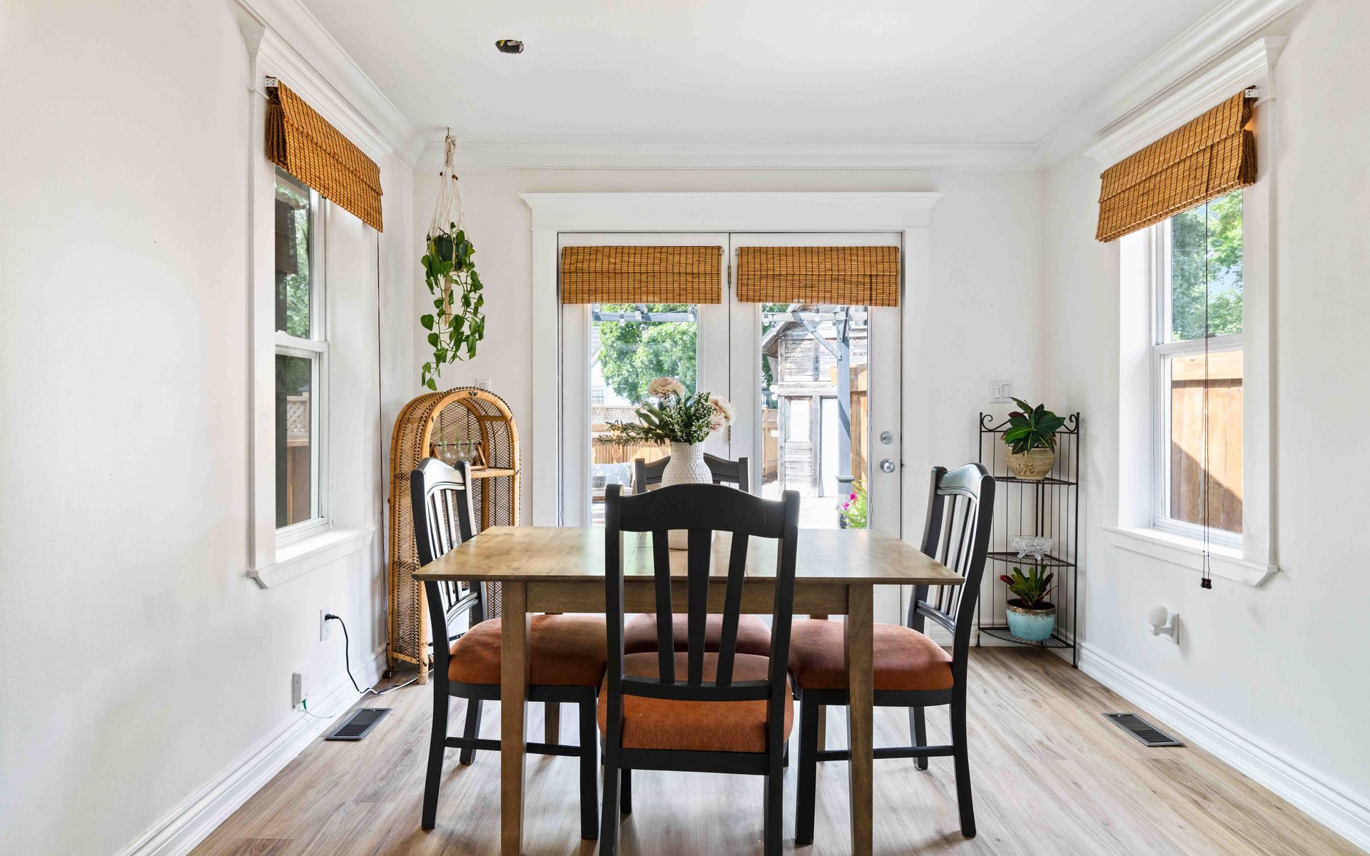 A dining room with a table and chairs and a sliding glass door.