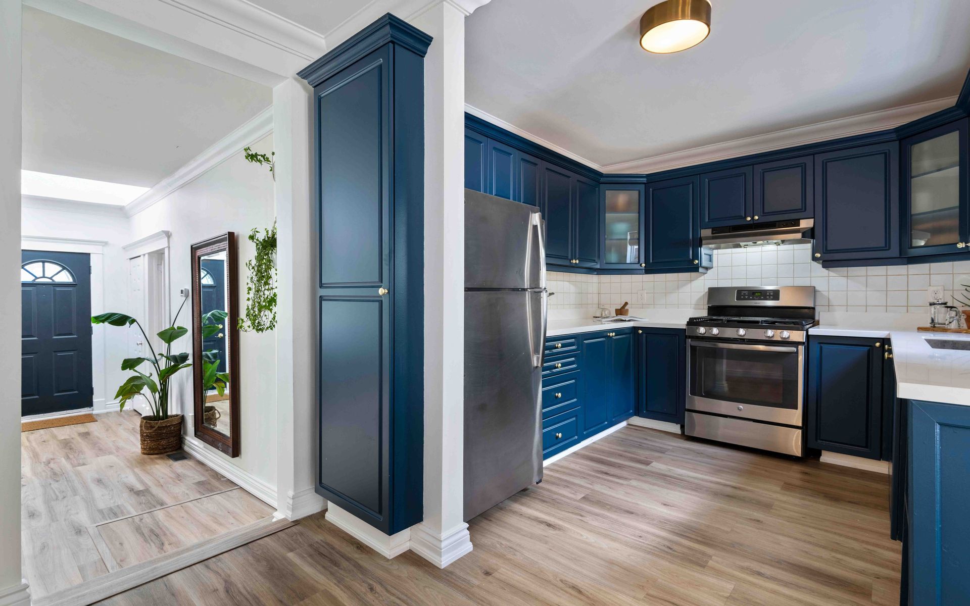 A kitchen with blue cabinets and stainless steel appliances.