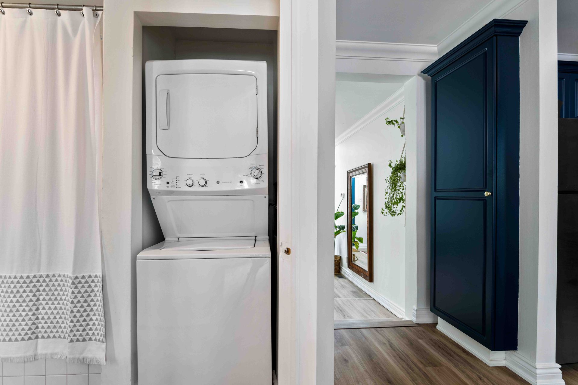 A washer and dryer are stacked on top of each other in a bathroom.
