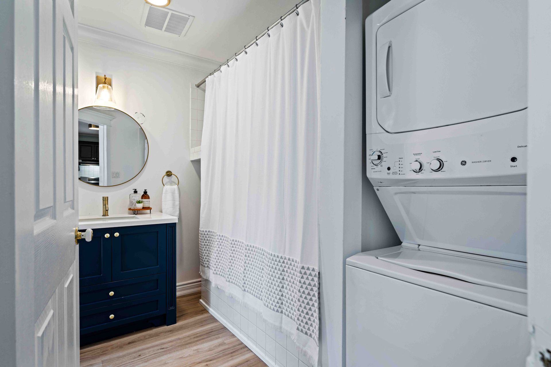A bathroom with a washer and dryer stacked on top of each other.