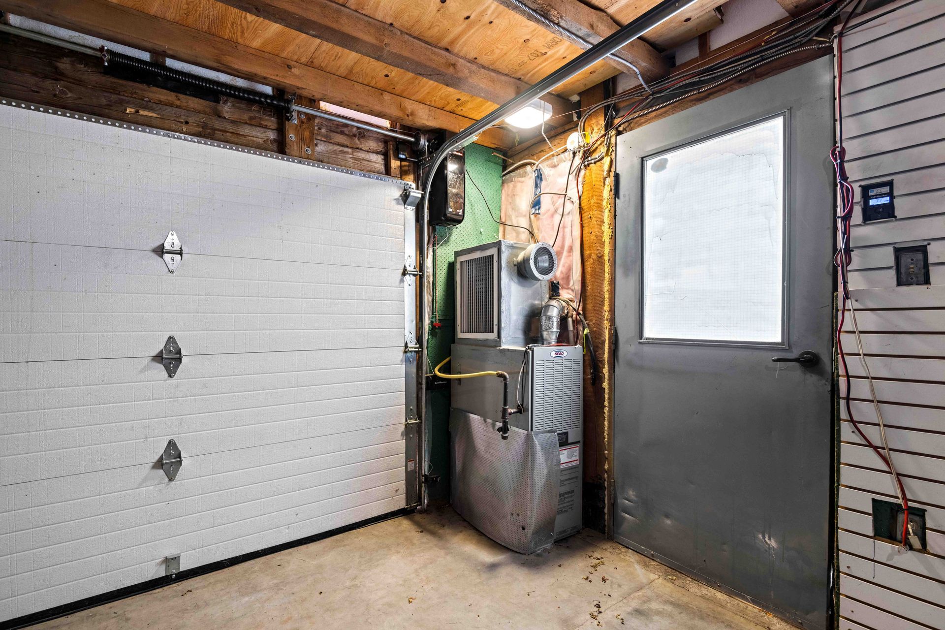 A garage with a garage door and a heater in it.