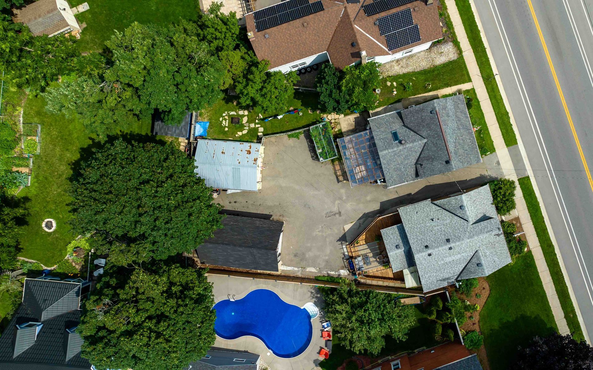 An aerial view of a residential area with a pool and houses.