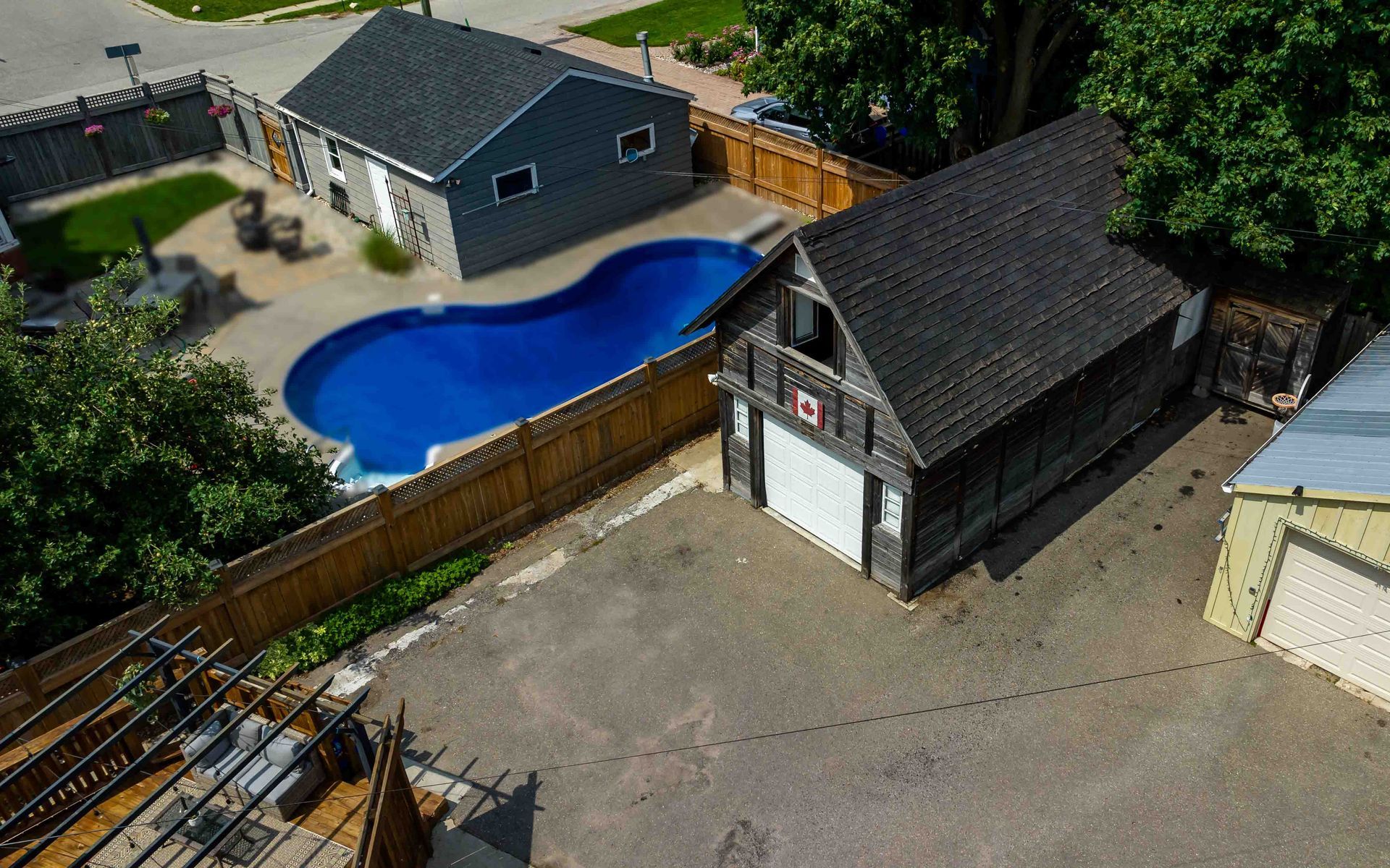 An aerial view of a house with a pool and a garage.