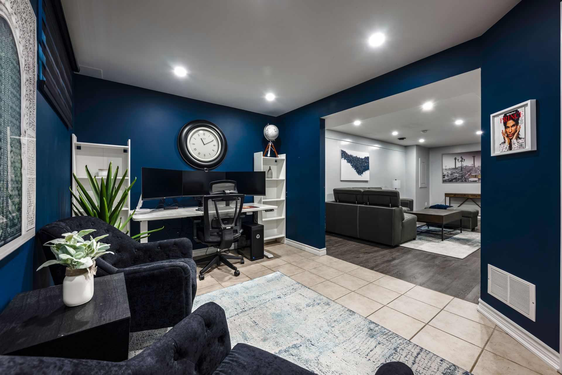 A living room with blue walls and a clock on the wall.