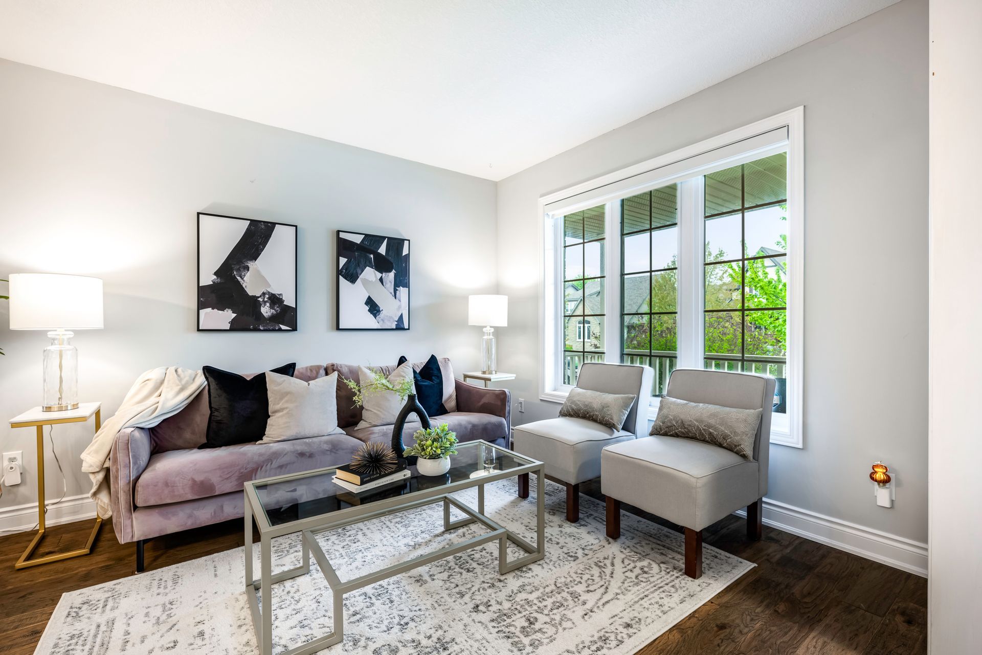 A living room with a couch , chairs , and a coffee table.