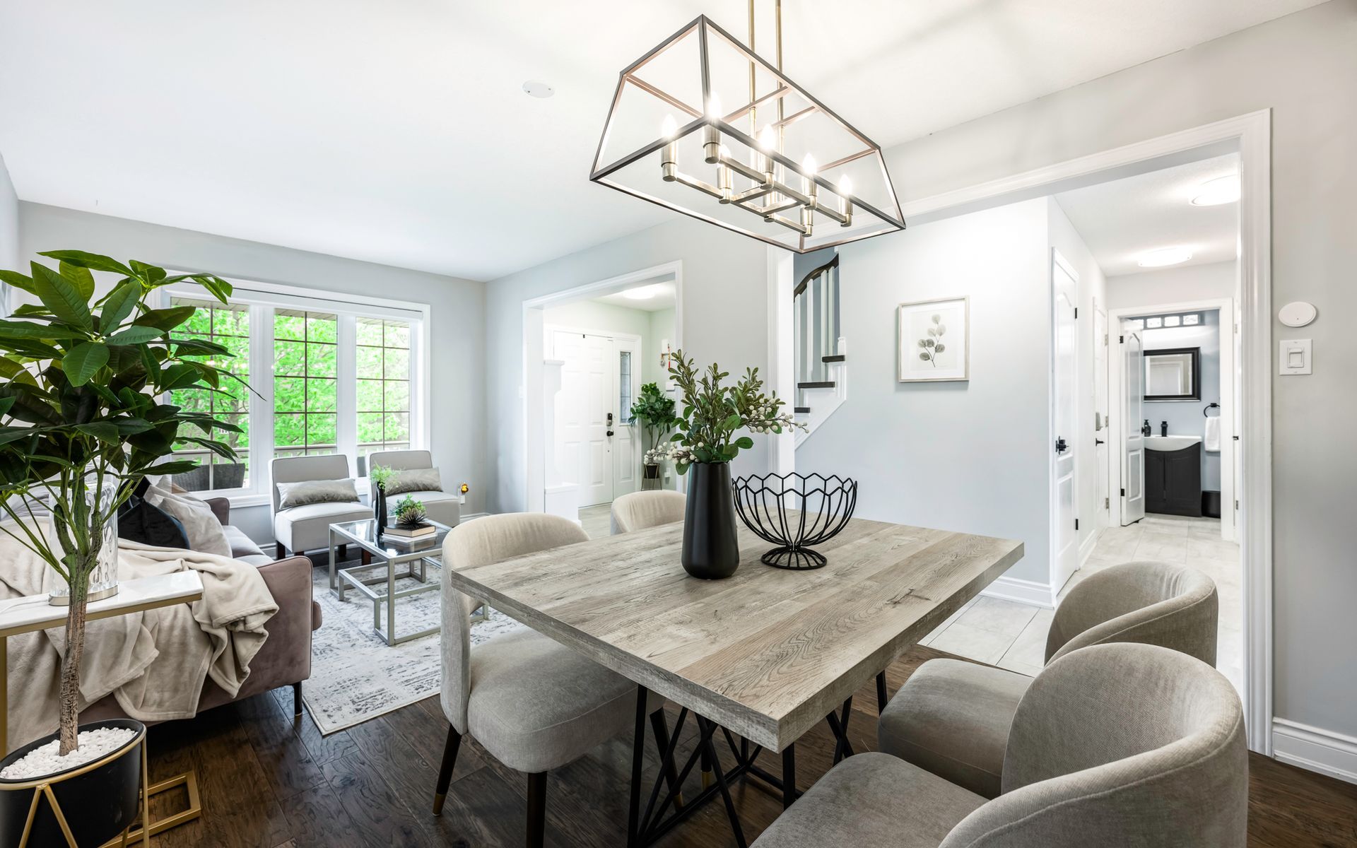 A dining room with a wooden table and chairs and a chandelier.